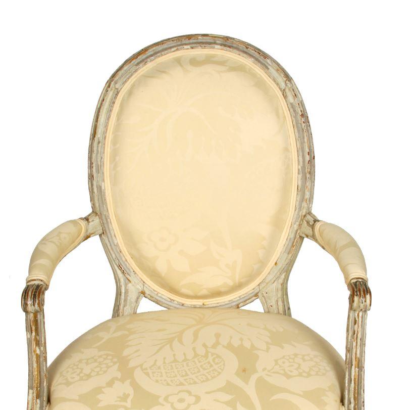 Louis XVI style painted fauteuil with oval back and pale yellow damask fabric.