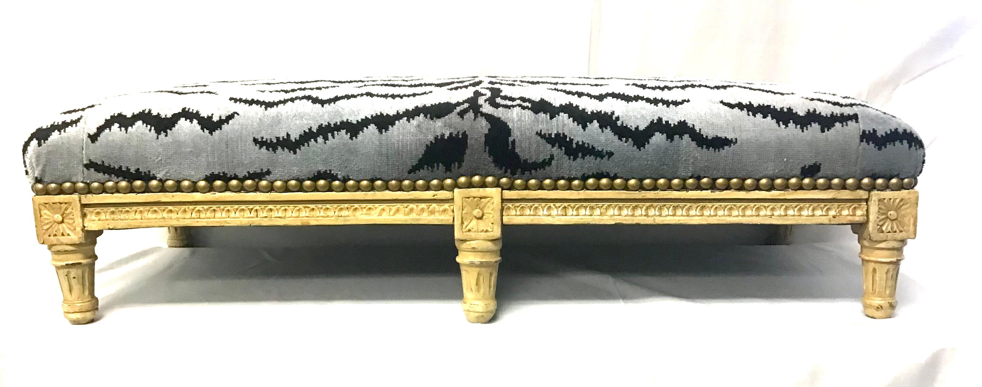 Louis XVI style carved and painted wood banquette/bench, 19th century Classic French design, great proportions and good condition. Squared Rosette, fluted, rounded tapered legs and covered in Scalamandre with brass tacks. Wonderfully worn painted
