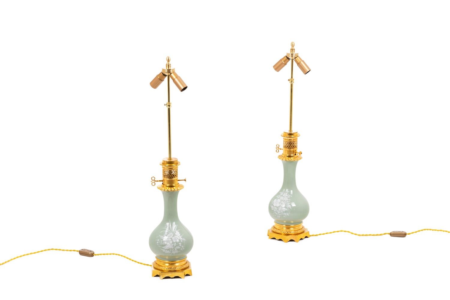 Pair of baluster-shape Louis XVI style lamps in celadon porcelain and embellished of gilt bronze. Body with floral decoration in white enamels. Laurel strips, godrons, cut base and openwork grid with diamond.

Work realized circa 1880.

New and