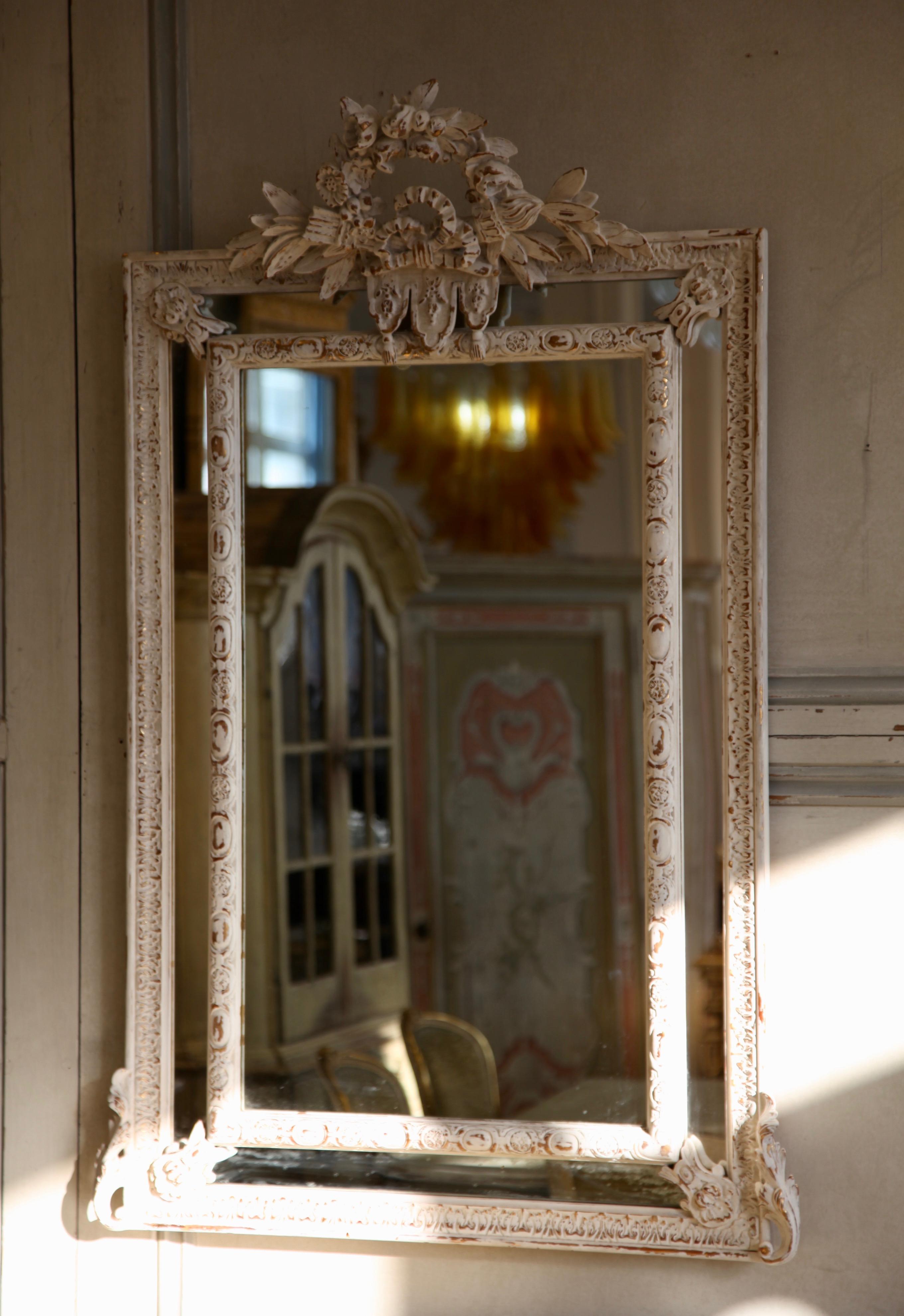 19th century style mirror of the Napoleon III period with Louis XVI ribbons and laurel leaves.
Gesso white on top of giltwood finish.
 