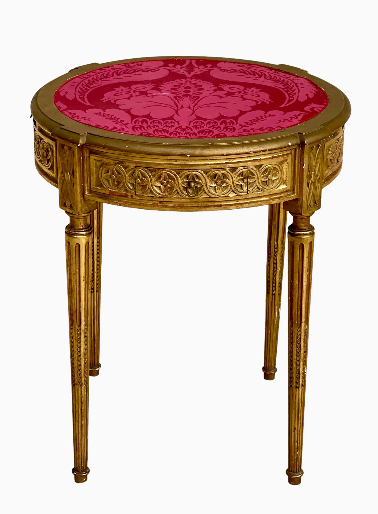 Louis XVI style gilded wood pedestal table composed of two pulls and two drawers around the edge. The top is covered with red fabric. Circa 1920.

Dimensions
Hauteur 70,5cm
Diamètre 60cm