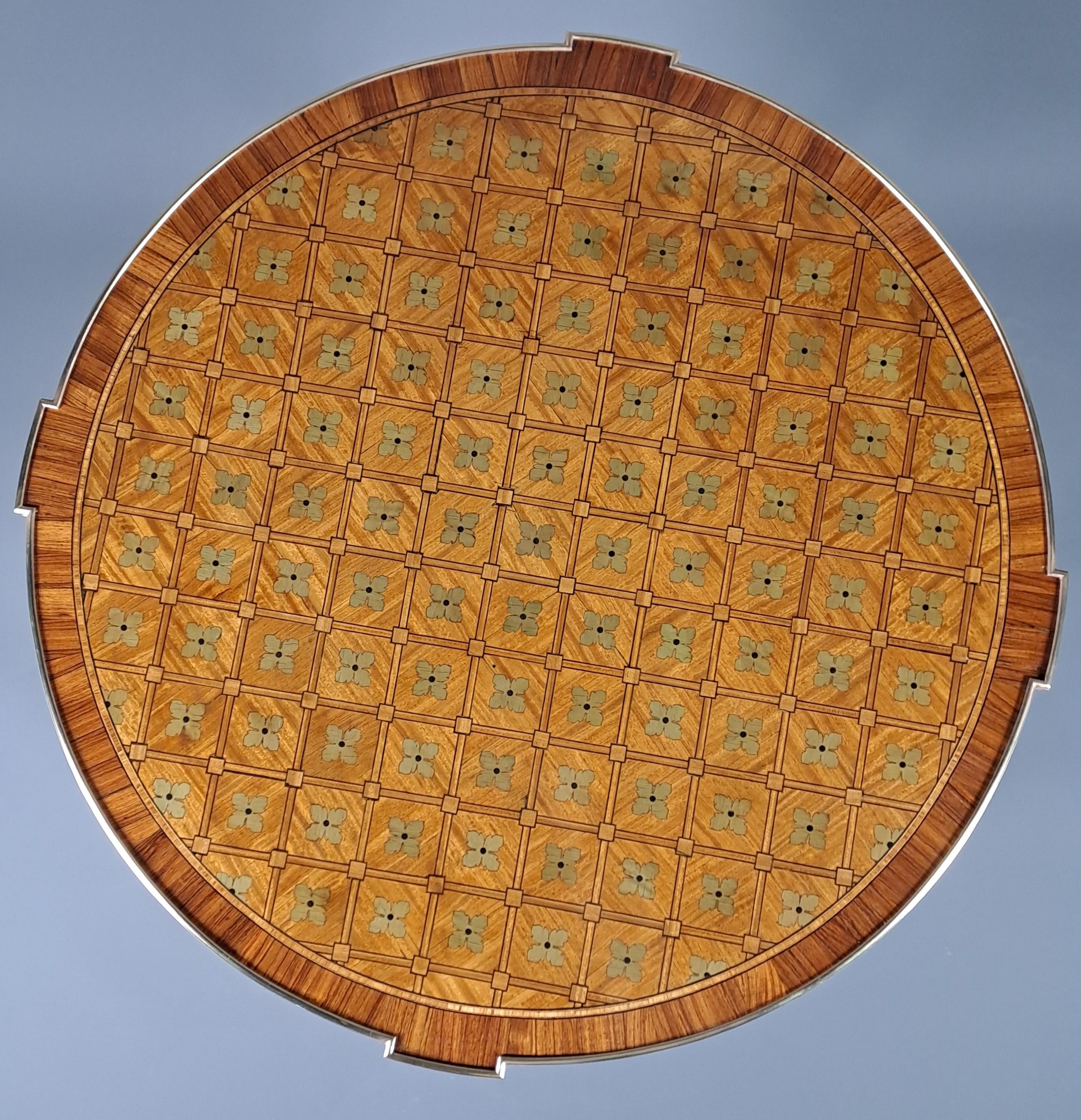 Very elegant Louis XVI style pedestal table with inlaid decoration of quartefeuilles presented in checkerboards on the top and in rings on the belt.

Note the projections up to the plateau directly above the four sheathed legs.

Opening a belt