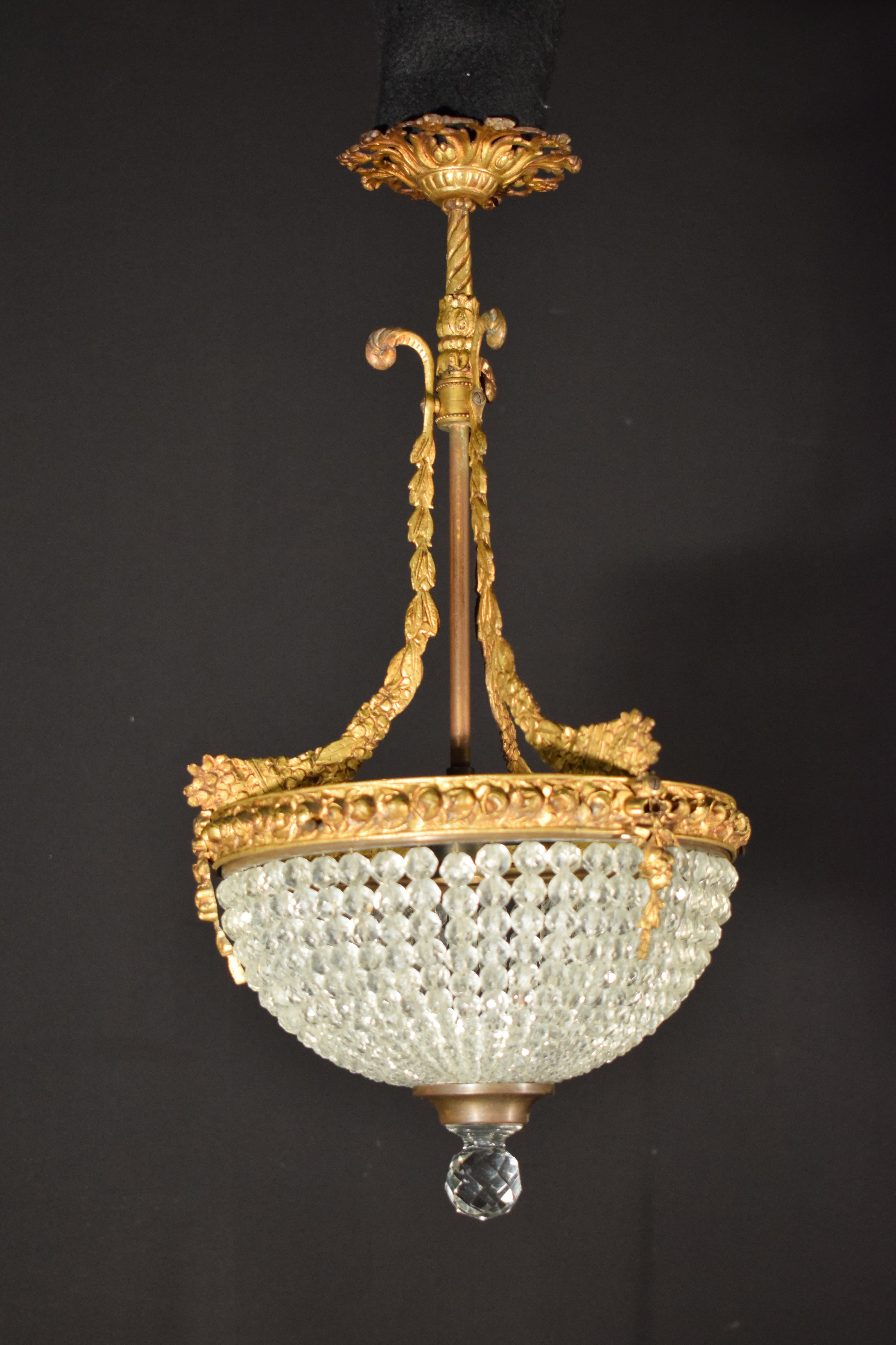 Ein feiner Anhänger aus vergoldeter Bronze. An der unteren Kuppel eine Gruppe von abgestuften, facettierten Kristallperlen. Frankreich, um 1920. 1 Licht. 
Abmessungen: Höhe 21