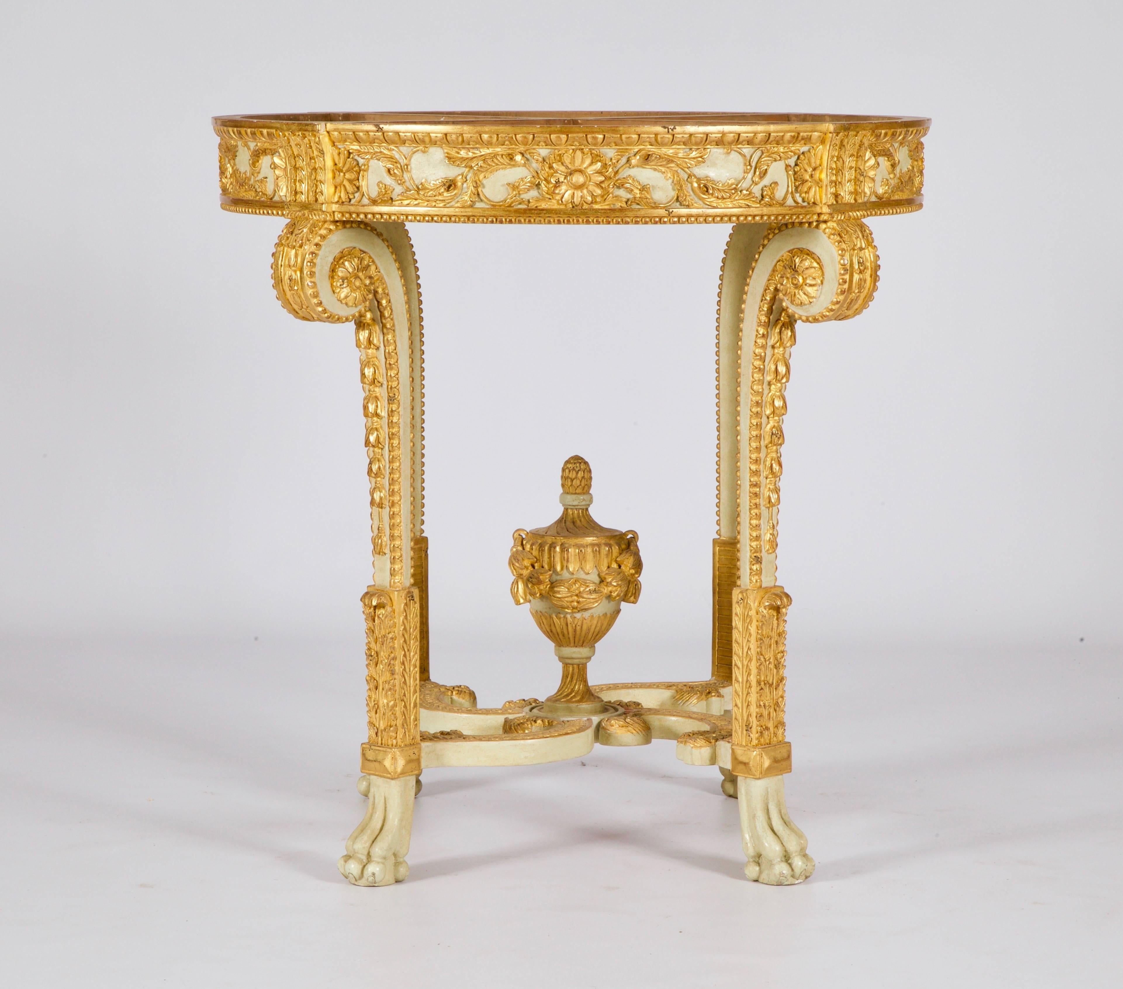  Louis XVI style round console table. Hand-carved by master craftsmen and hand finished in an aged polychrome gilded and ecru/white patina made using traditional methods and materials. A beveled top can be made to order from our marble selections on