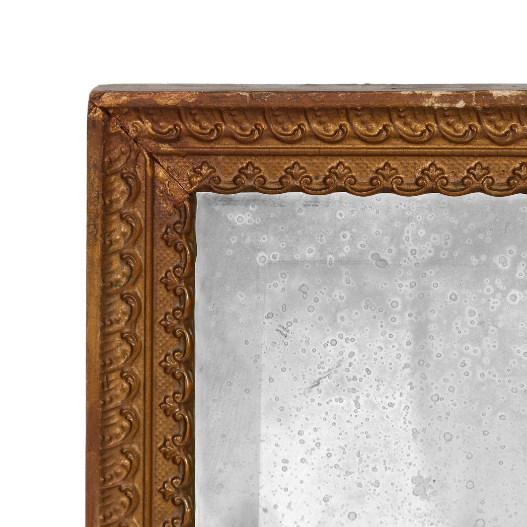 A vintage Louis XVI style rectangular giltwood mirror. The frame is a beautifully detailed with giltwood scrolls, beads and small acanthus leaf surrounding the mirror.  The mirror is quite antiqued with signs of patina consistent with age, and more
