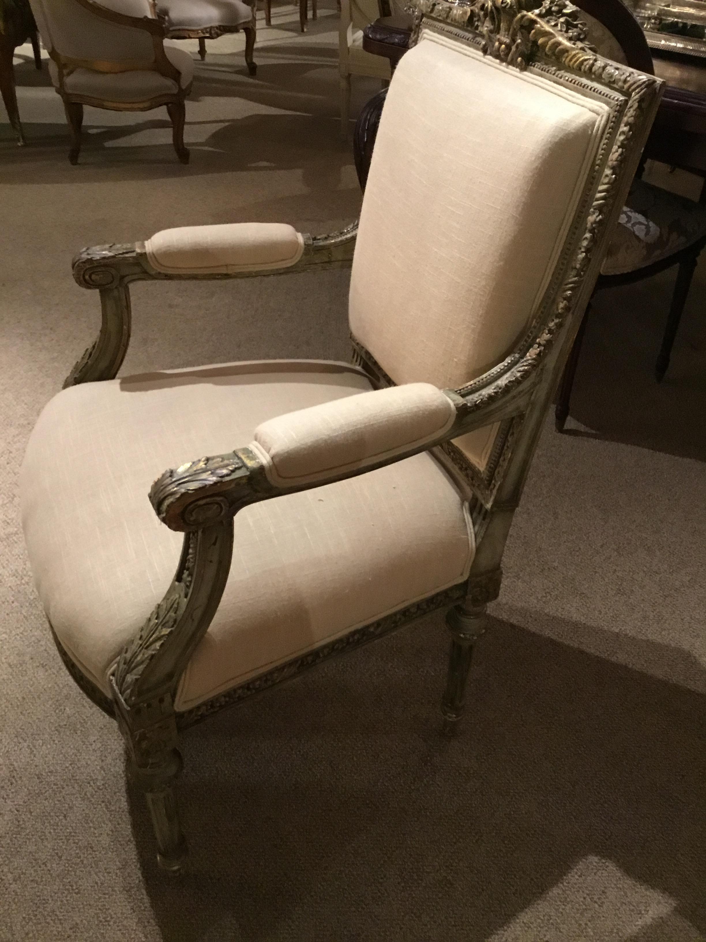 Beautifully carved French Louis XVI-style armchair painted in original French green hue, 19th century
With gilt highlights, having a reeded carved leg. New upholstery in cream linen.