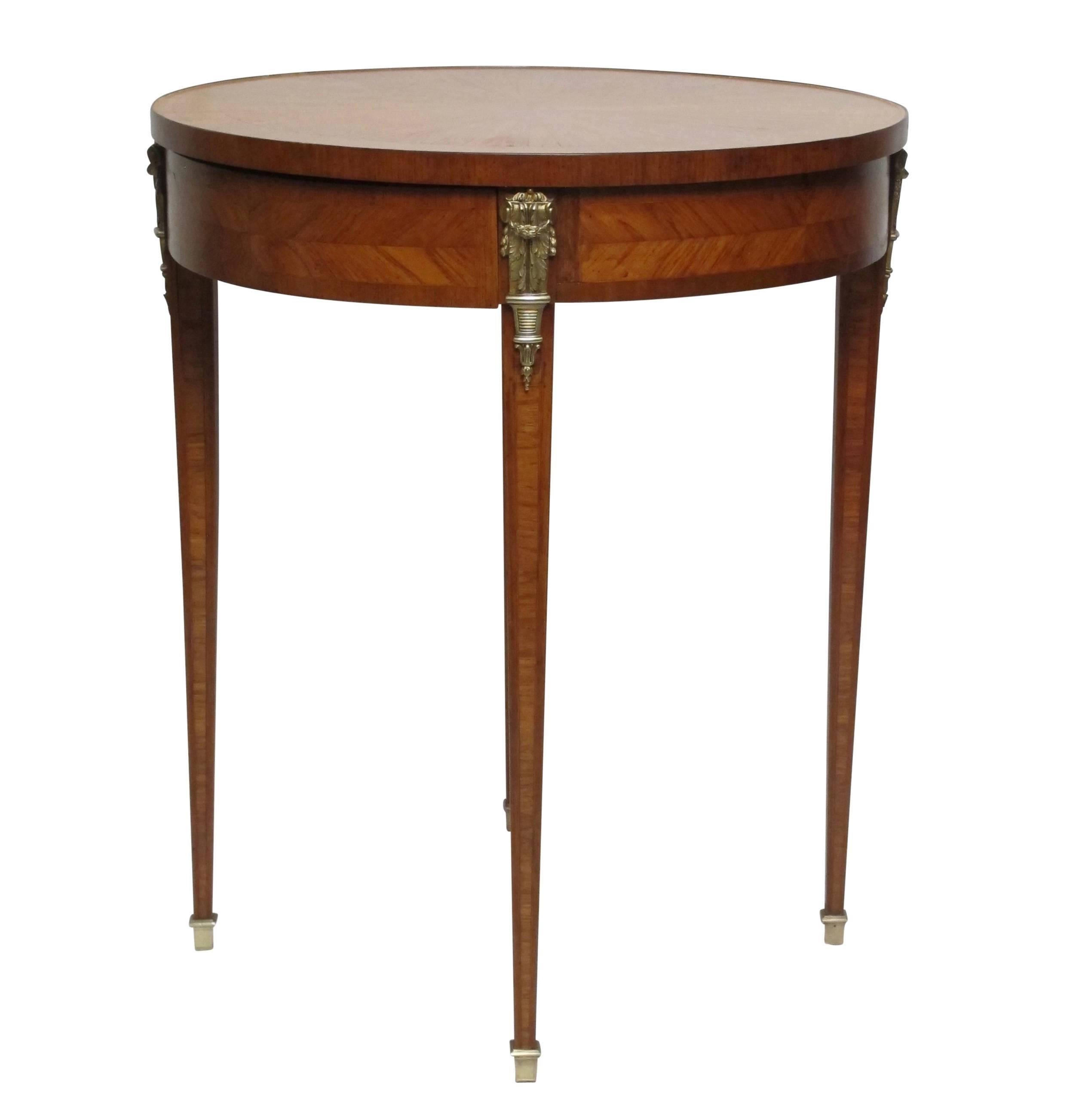 Attractive and unusual satinwood Bouillotte table having mahogany cross banding, brass mounts and sabots, France, circa 1950.