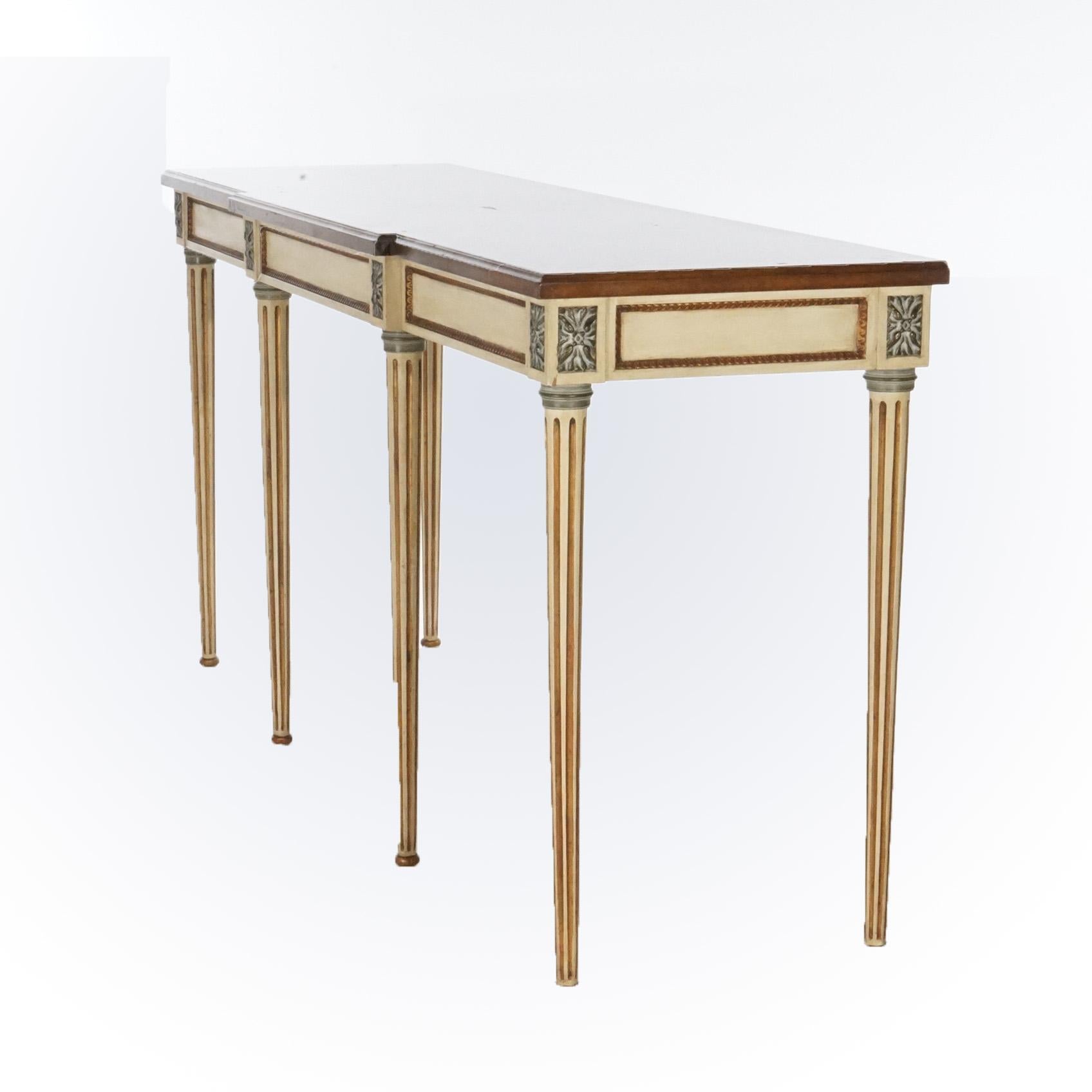 A French Louis XVI style console or sofa table offers shaped, beveled and bookmatched satinwood top over polychrome base having gilt rosettes over reeded and tapered legs having gilt highlights, 20th century

Measures- 34.5''H x 72''W x 21''D.