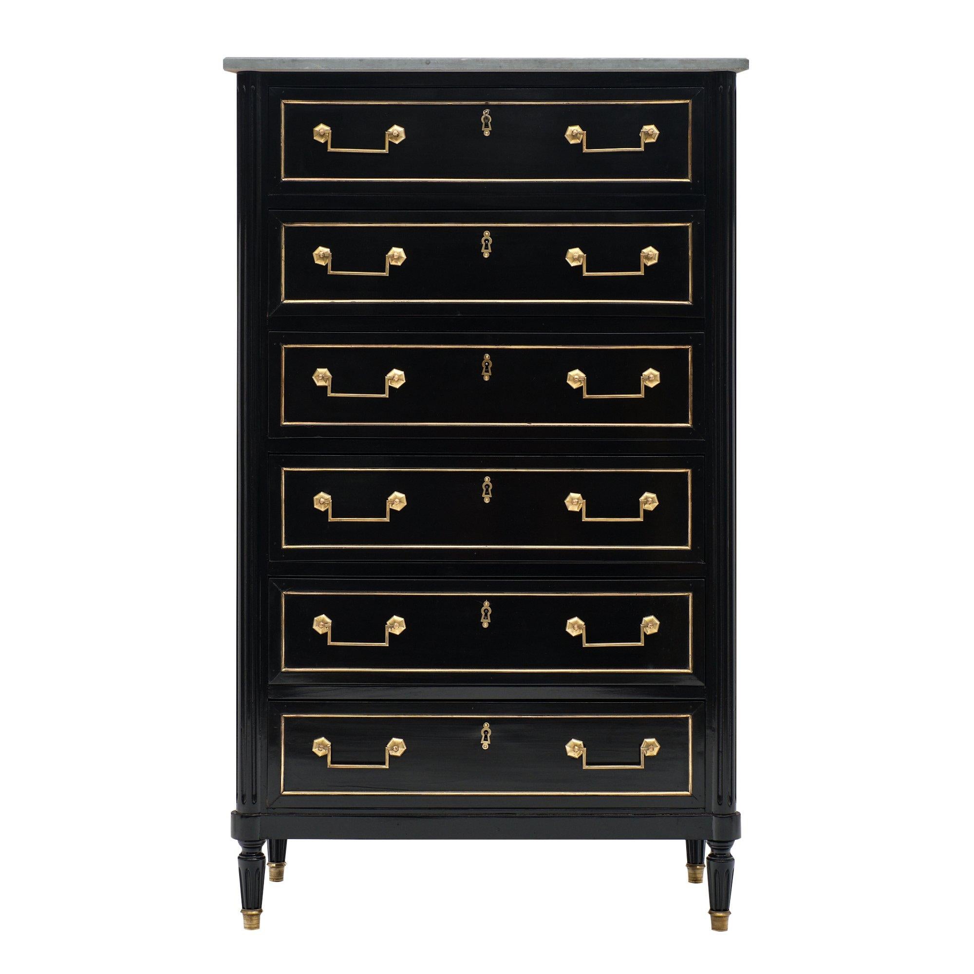 Louis XVI style semainier with gray Sainte Anne marble top and an ebonized French polish finish. We love the original brass trim and hardware throughout. Six dovetailed drawers offer functionality. This piece is in excellent antique condition.