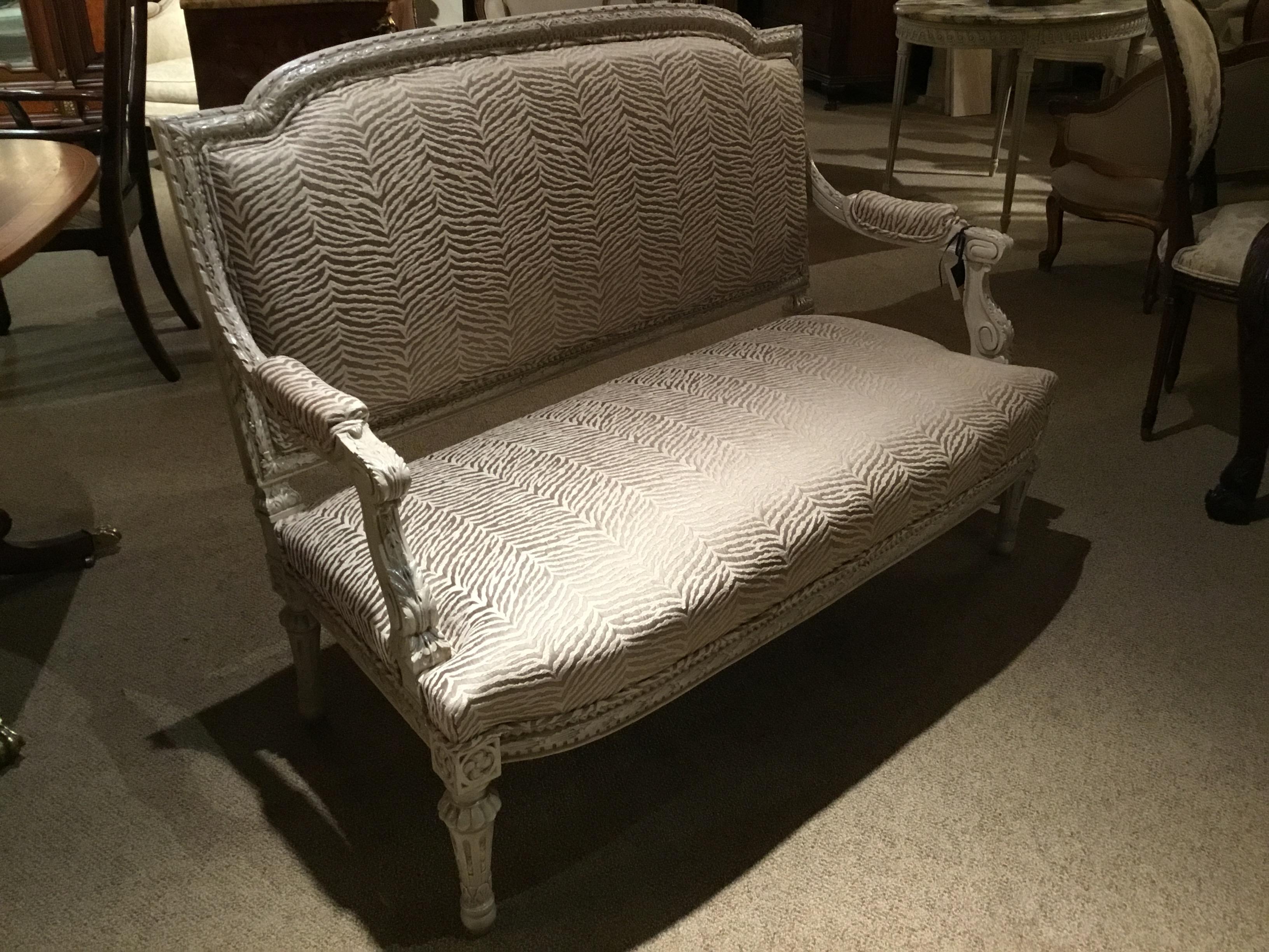 19th century settee with new upholstery, polychromed in pale cream color hue. Scrolled arms
with a slightly arched crest rail. Reeded straight legs.