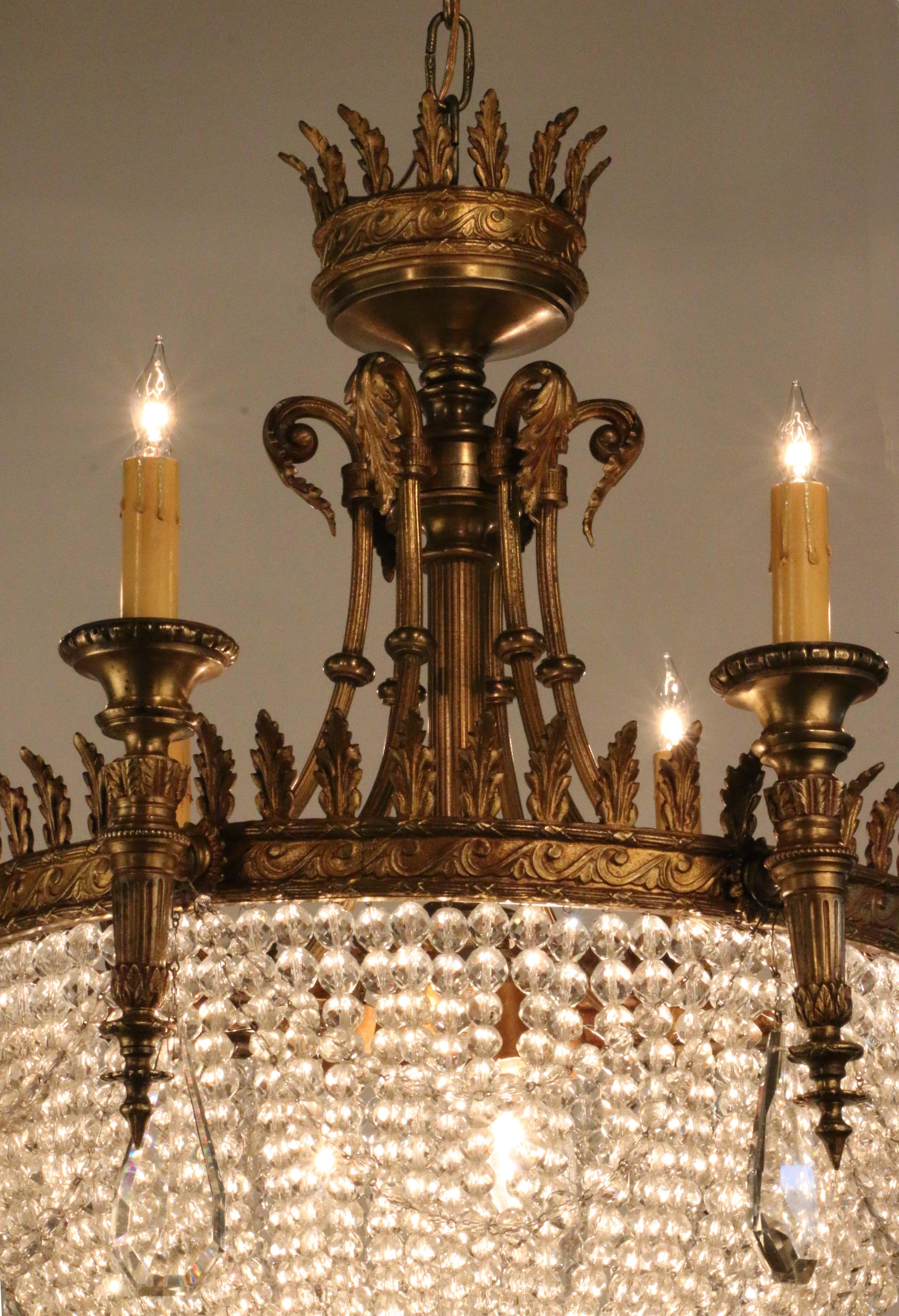 This is a Classic Louis XVI style, offering a highly decorative light source filtered through exquisite graduated lead crystal beads, together with six torch-shaped electrified 