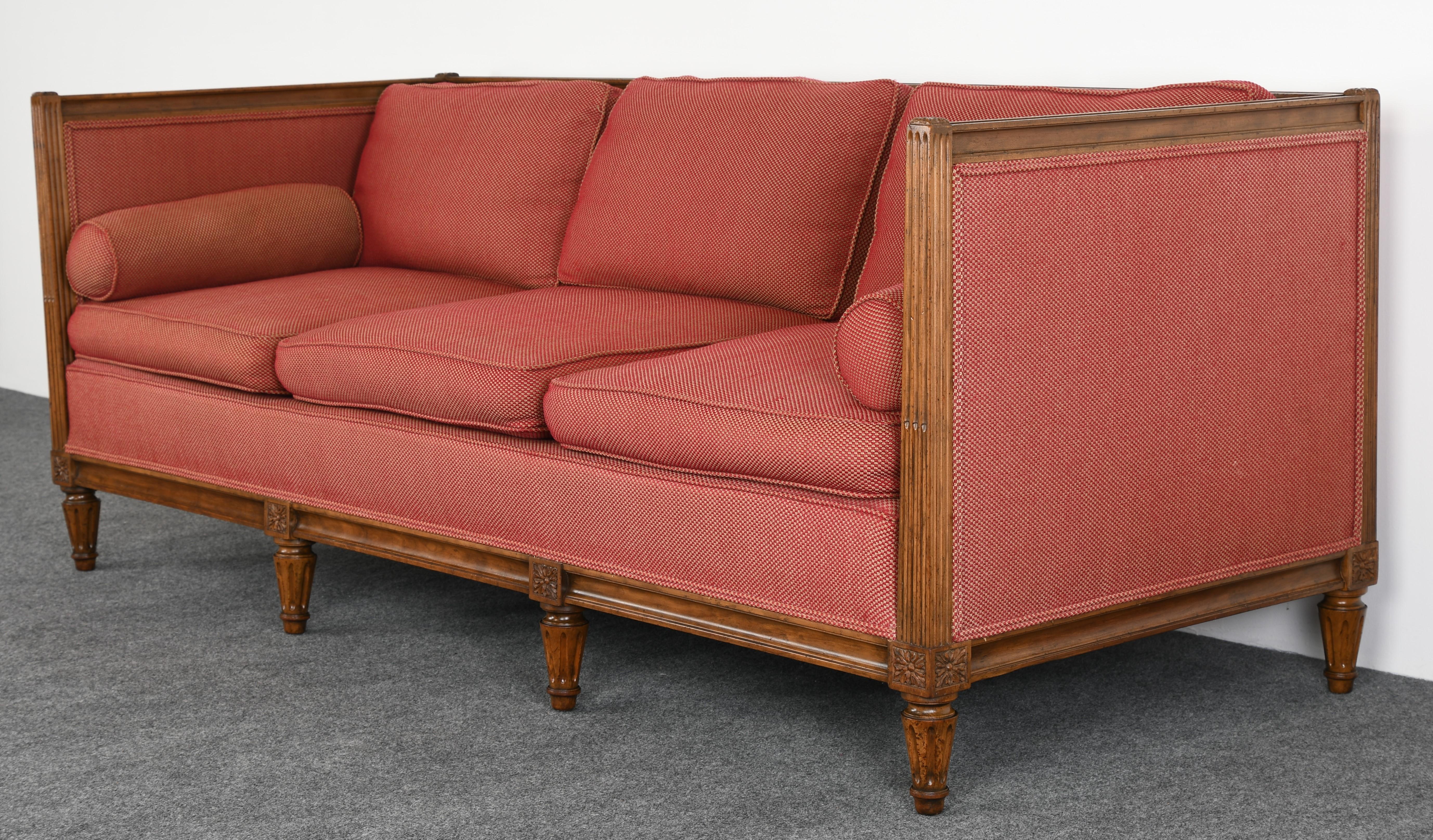 A stately Louis XVI style sofa by Baker Furniture Company with walnut frame and upholstery. New upholstery suggested, however, can be temporarily used as found. The fabric is in overall good condition with some spots. Structurally sound. Originally