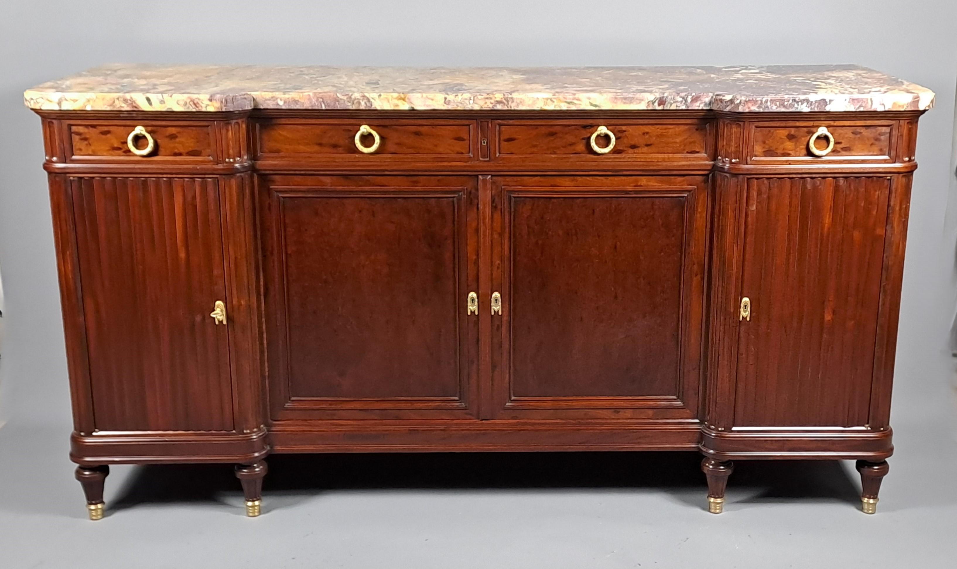 Superba credenza in mogano maculato in stile Luigi XVI con nicchia centrale, doppia anta e due ante sui lati che simulano tende, quattro cassetti nella fascia.

Eccezionale piano in marmo di fiori di pesco dai colori scintillanti, modanatura a
