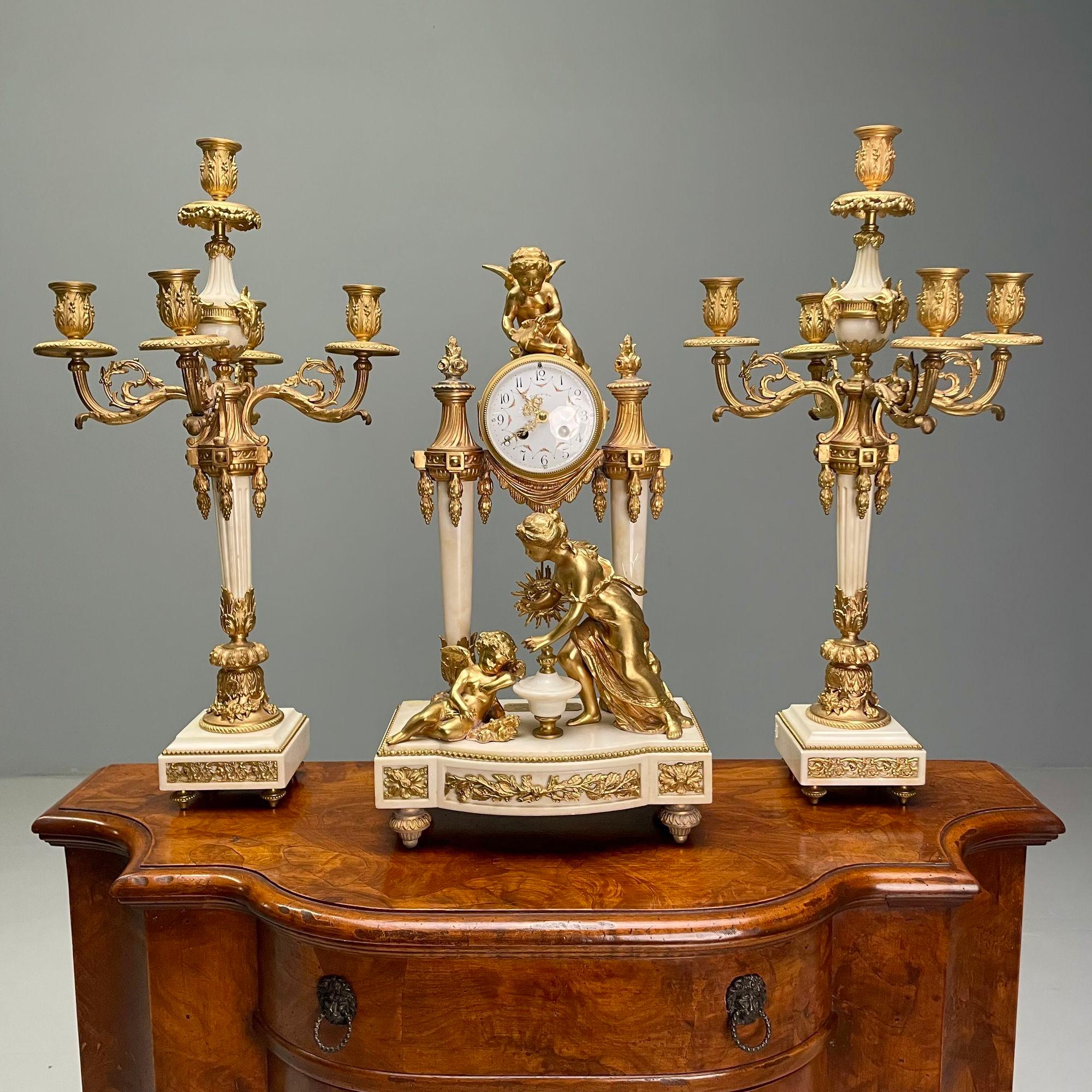 Louis XVI Style, Three Piece Clock Garniture, Gilt Bronze, Marble, France, 1920s

A finely cast bronze and marble clock set depicting Leto and her Children Apollo and Diana. The set having a Made in France Foundry Stamp and a Plaque marked Auguste