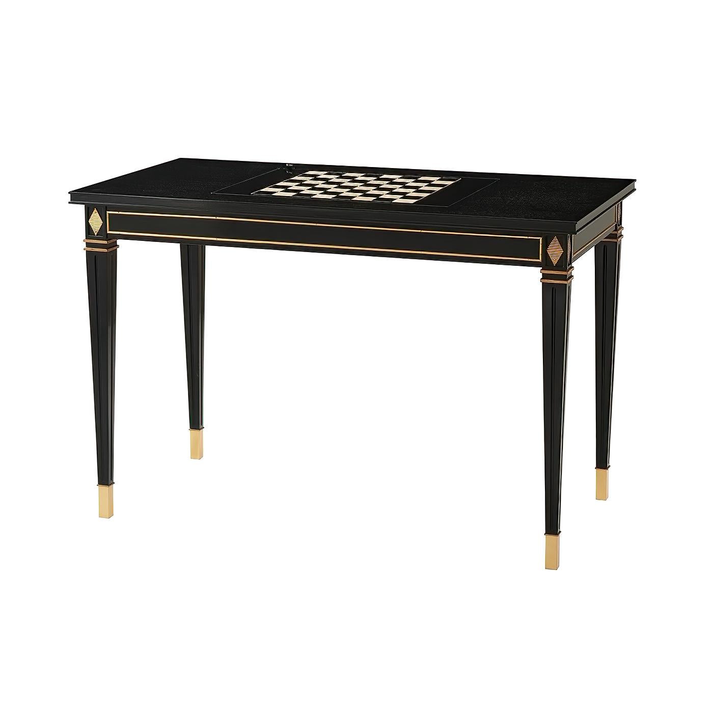 A French style tric trac game table reversible to a writing table. The ebonized mahogany table with a reversible top panel with a backgammon and chess/checkerboard with counter well, with two drawers on the paneled frieze, raised on square tapered