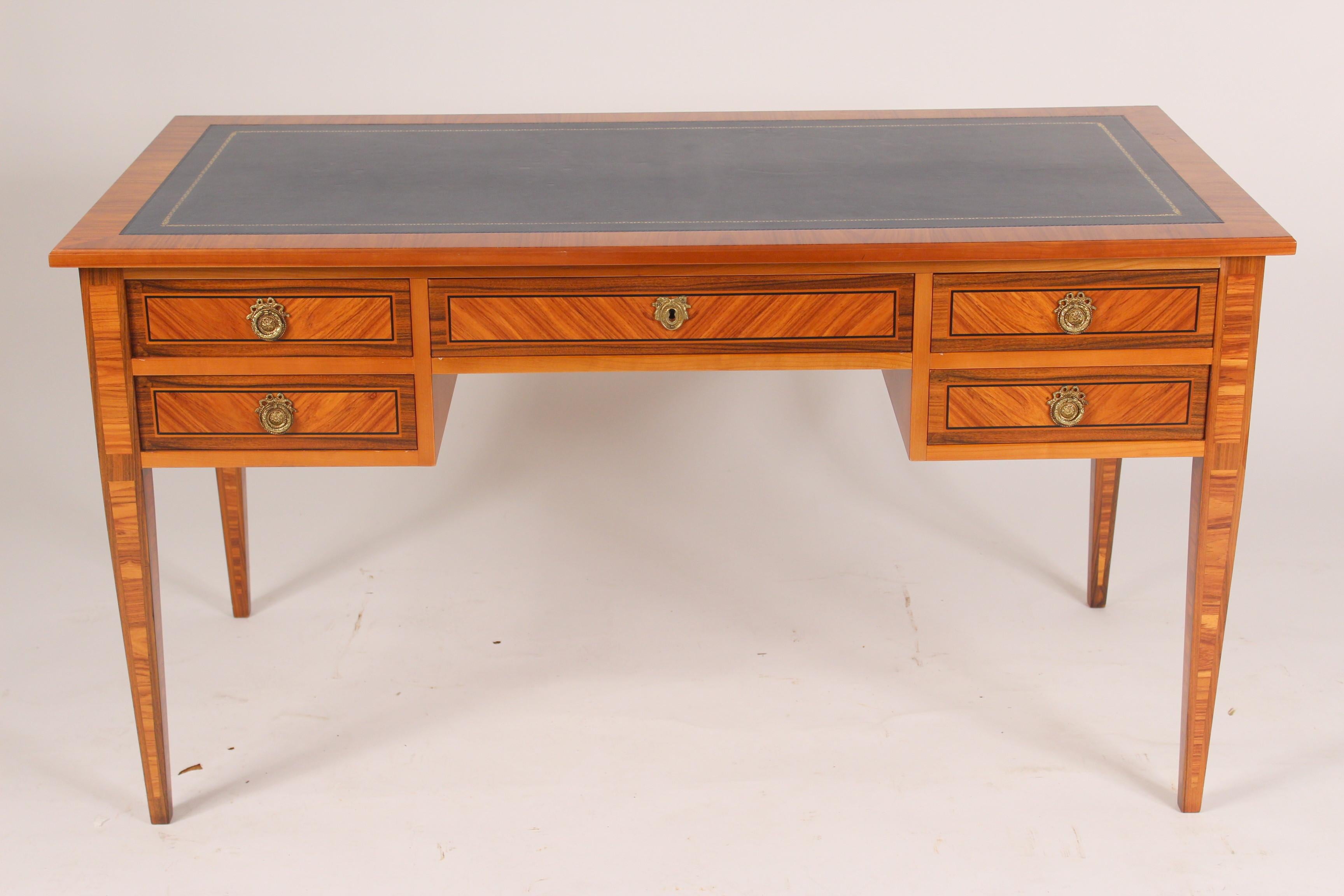 Louis XVI style tulip wood and king wood desk with a blue tooled leather top and pull out writing slides on each end, late 20th century.