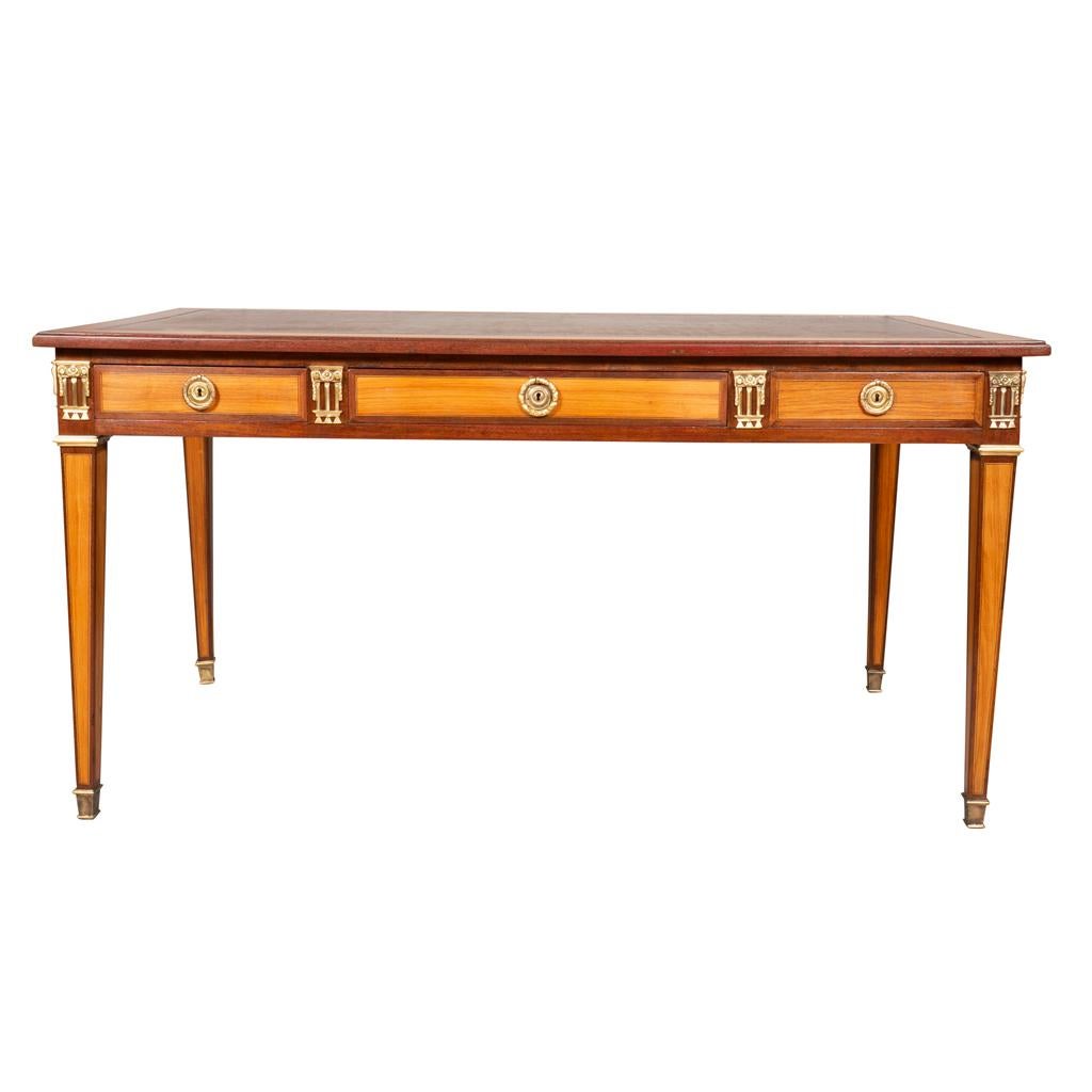 Louis XVI Style Tulipwood and Purpleheart bureau plat. An original furnishing from the Waldorf Towers in New York City. Newly replaced tooled brown leather set in a rectangular top with banded border over three drawers with opposing drawers. Raised