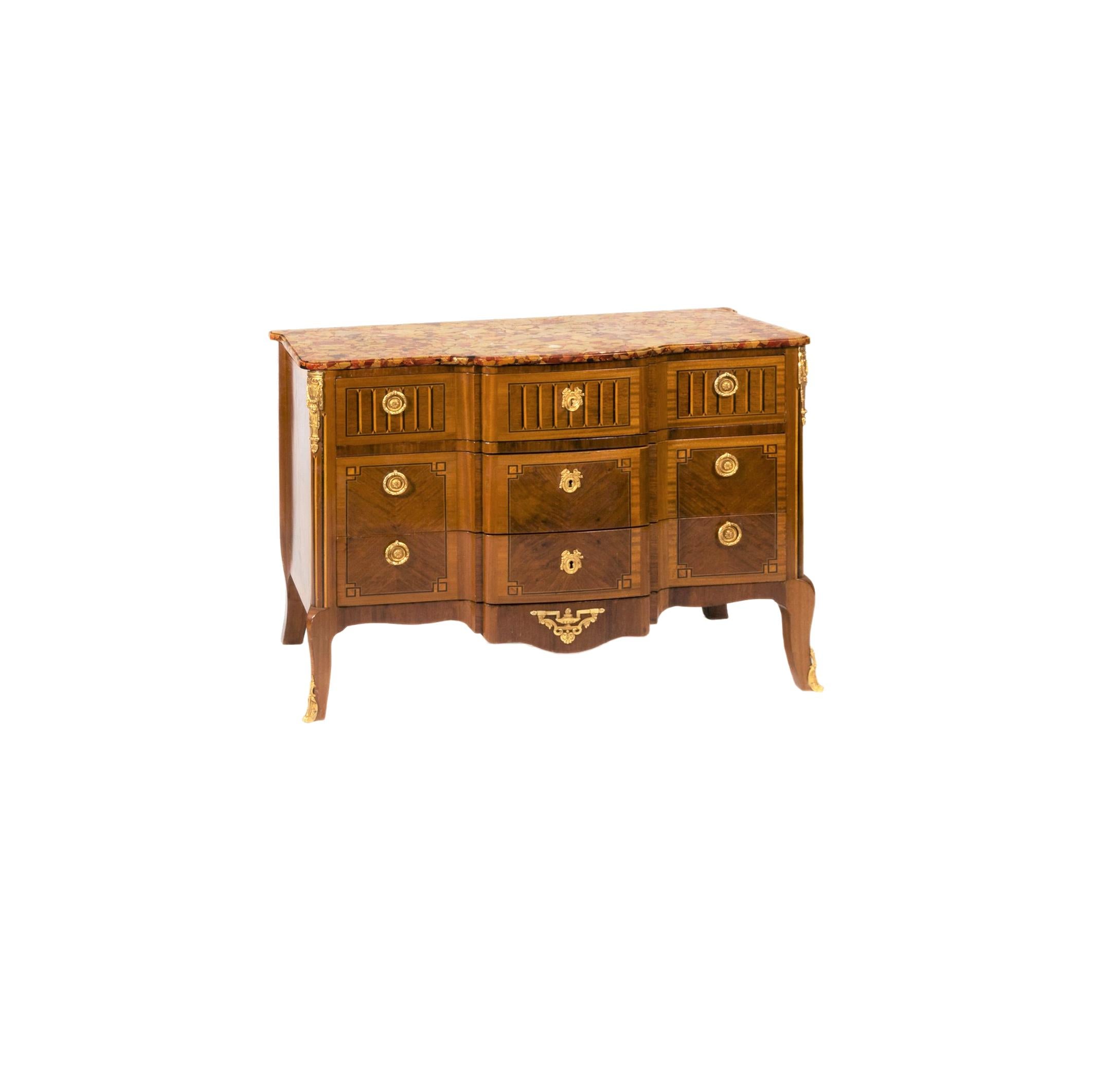 A marble top of breakfront shape with molded edge, three long shaped drawers of tulipwood veneer panels with ebony stringing, top drawer inlaid with ebony and sycamore design. 
Gilt brass laurel wreath handles, gilt brass escutcheons with central