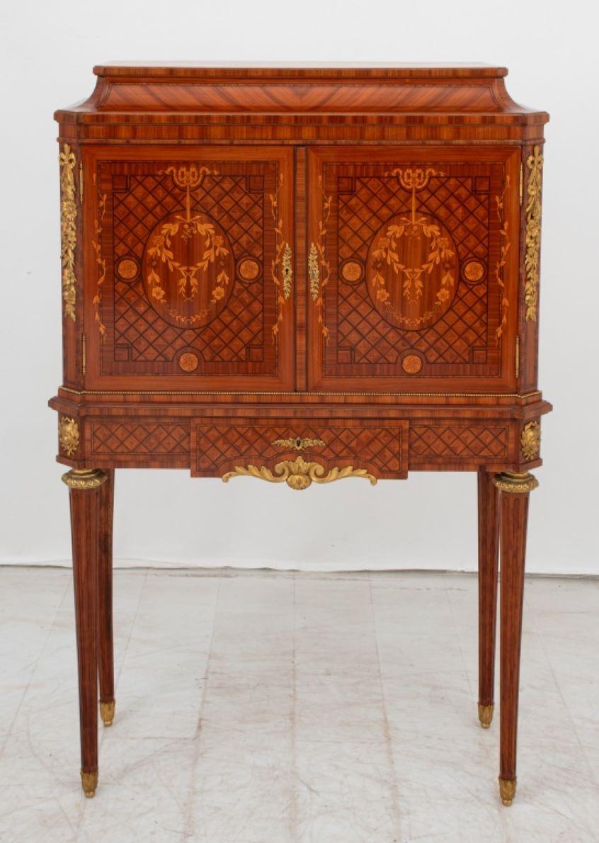 Louis XVI Style Gilt Metal Mounted Tulipwood Marquetry Cabinet, two doors above single central drawer with leather lift top vanity mirror, on four fluted tapered legs. 51.5