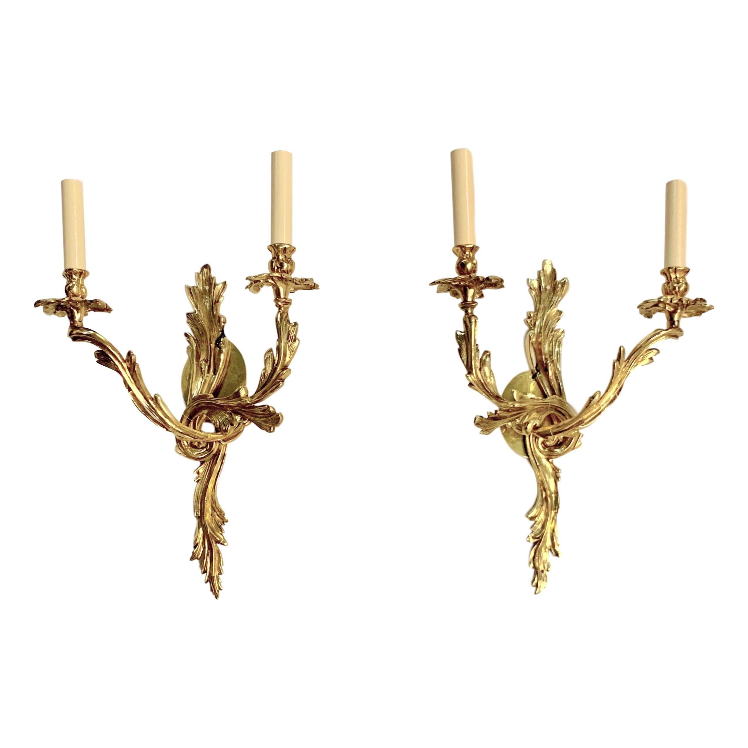 A pair of circa 1920's French Louis XV style gilt bronze 2-light sconces.

Measurements:
Height: 21