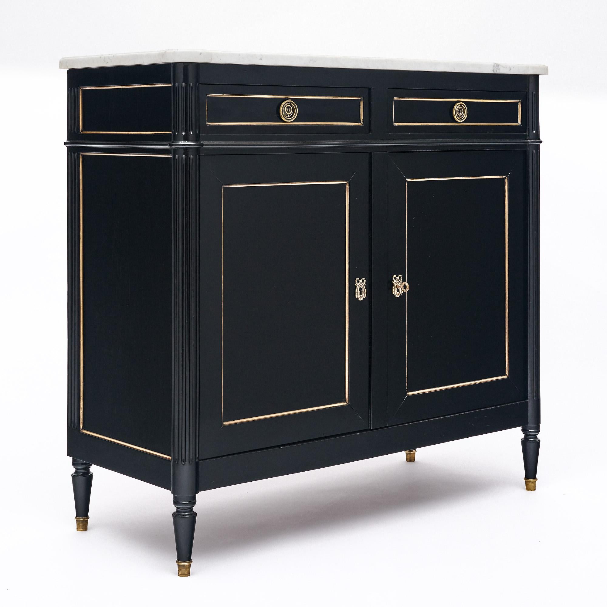 Buffet from France in the Louis XVI style made of mahogany that has been ebonized and finished with a lustrous Museum quality French polish. There are two dovetailed drawers above two doors; all trimmed in gilt brass. This elegant credenza is topped