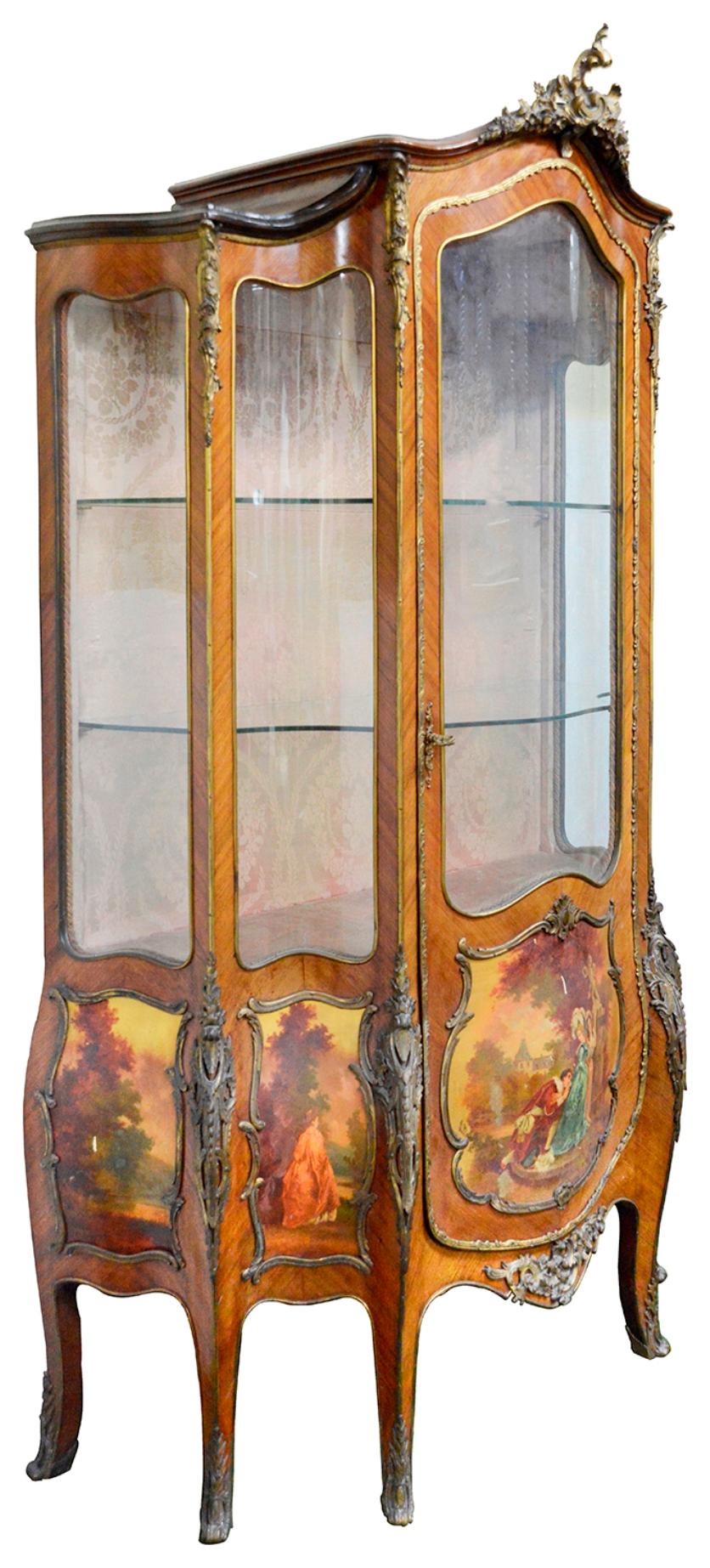 A very imposing late 19th Century French Louis XVI style bombe fronted glass Vitrine, having gilded ormolu scrolling foliate mounts, hand painted panels to the sides and door depicting romantic scenes, raised on six elegant out swept legs
