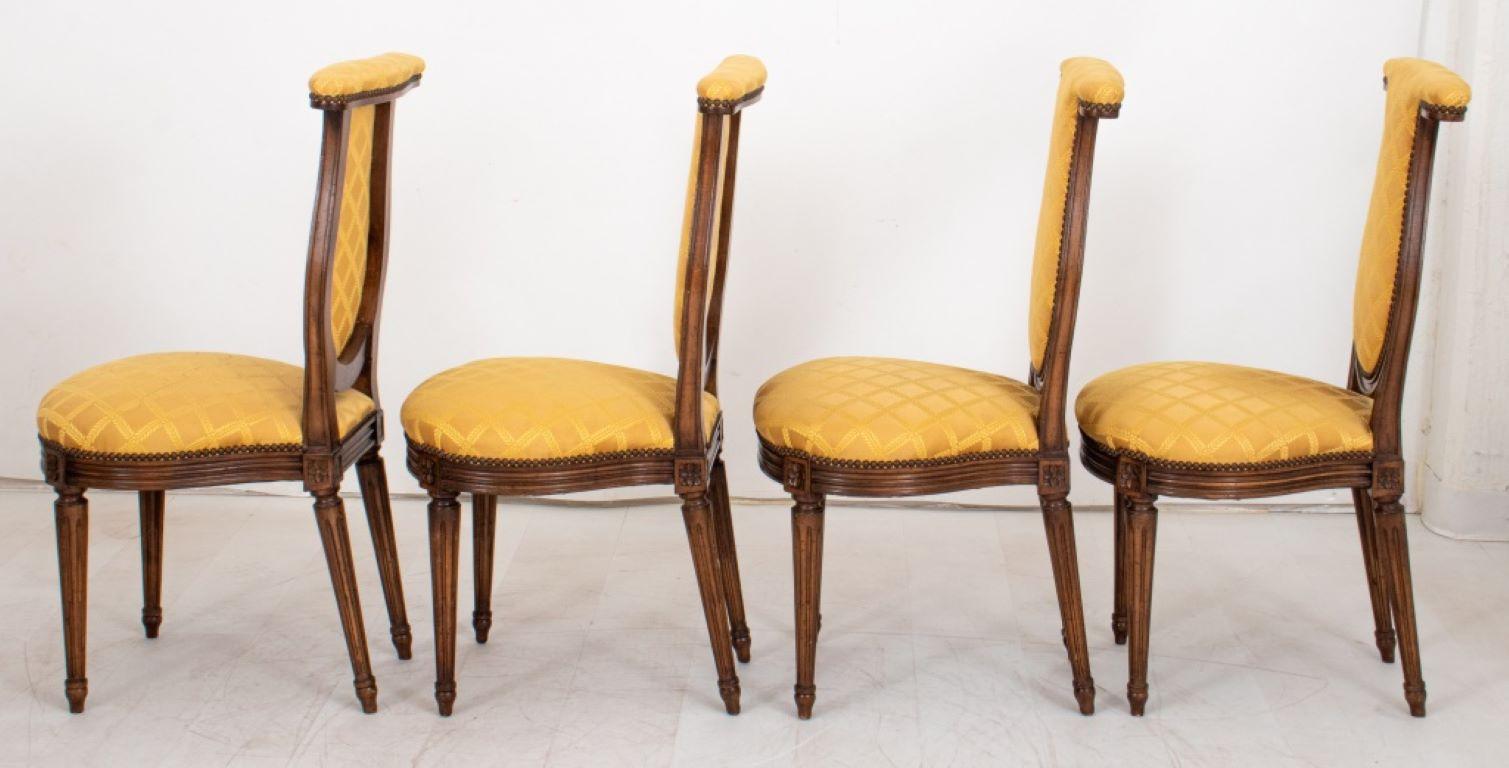 Set of Four Louis XVI Style Mahogany 'Voyeuses' or Side Chairs, each with arm rail at crest above lyre-shaped upholstered back and seat on molded seat rail with paterae-headed tapering columnar stop-fluted legs, now upholstered in trellis-patterned
