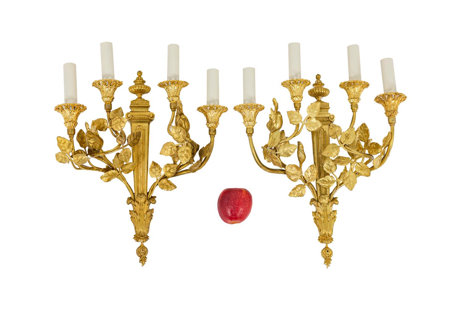 Louis XVI style wall sconces in gilt wood with four fires. Cups in openwork with vegetal motifs standing on a S-arm adorned with leaves.

Work realized in the 20th century.

 