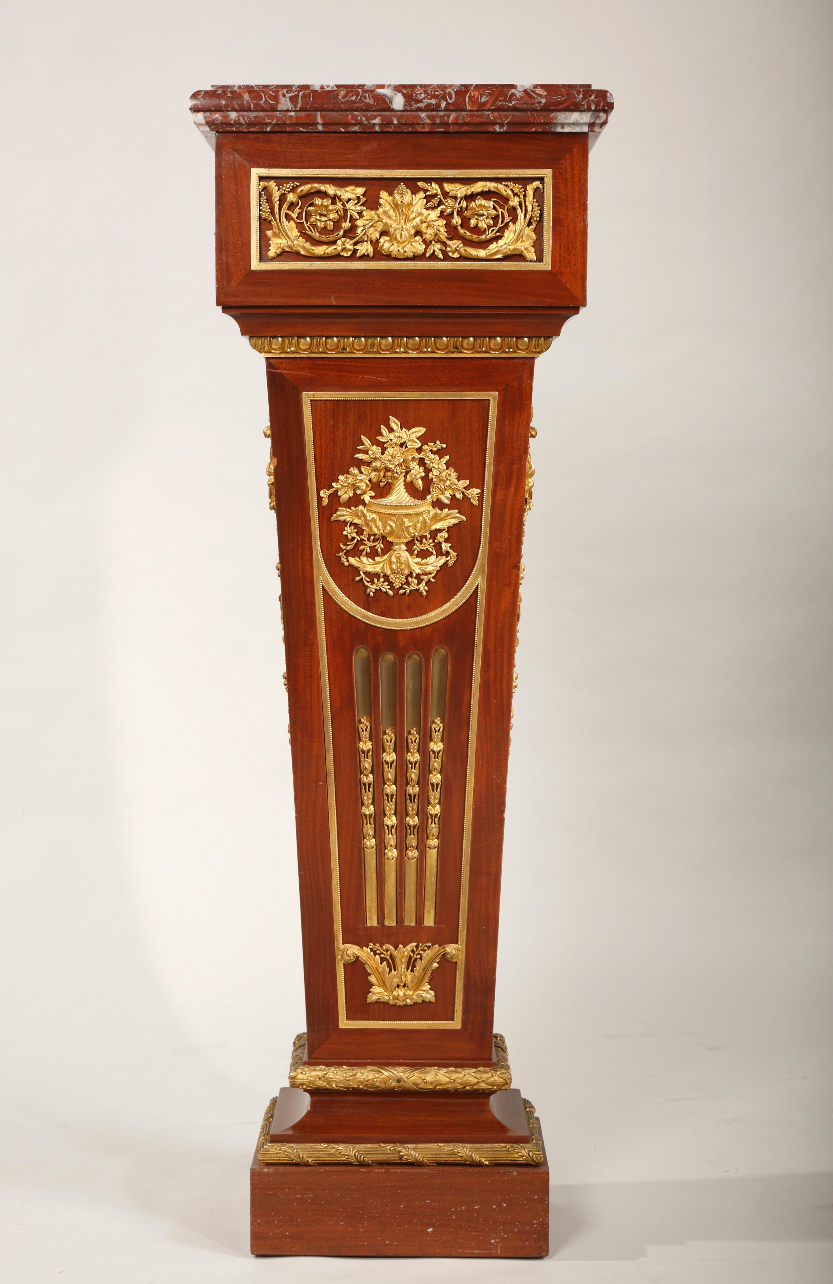 Un piédestal de style Louis XVI en bois plaqué, monté avec de fins ornements en bronze doré. Garni de marbre 
