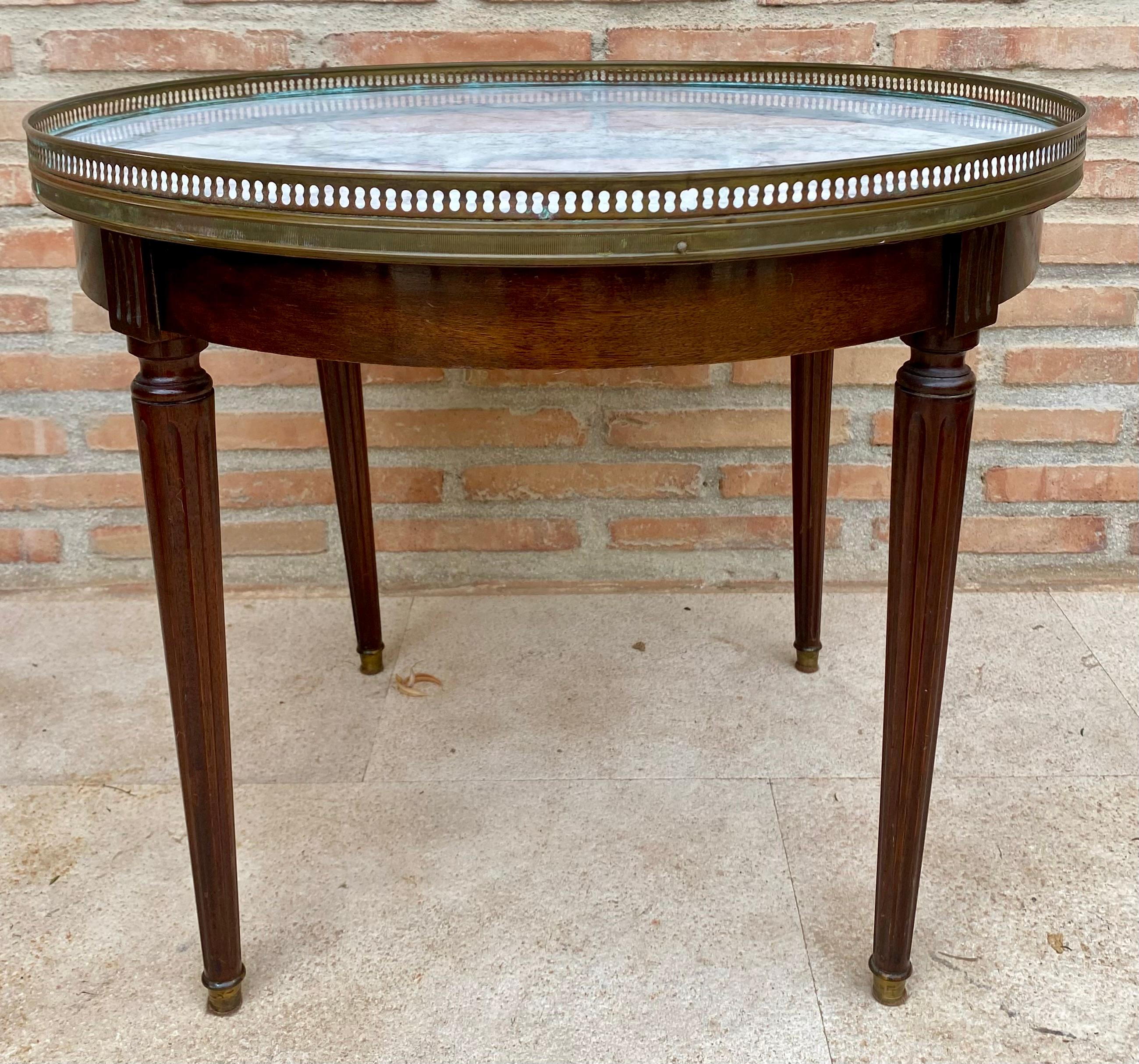 Louis XVI style Bouillotte table in walnut and marble top, 19th century. The circular top of variegated white marble within a perforated brass gallery, on a frieze, raised on fluted and tapered circular legs ending in brass caps.

Minor damage to