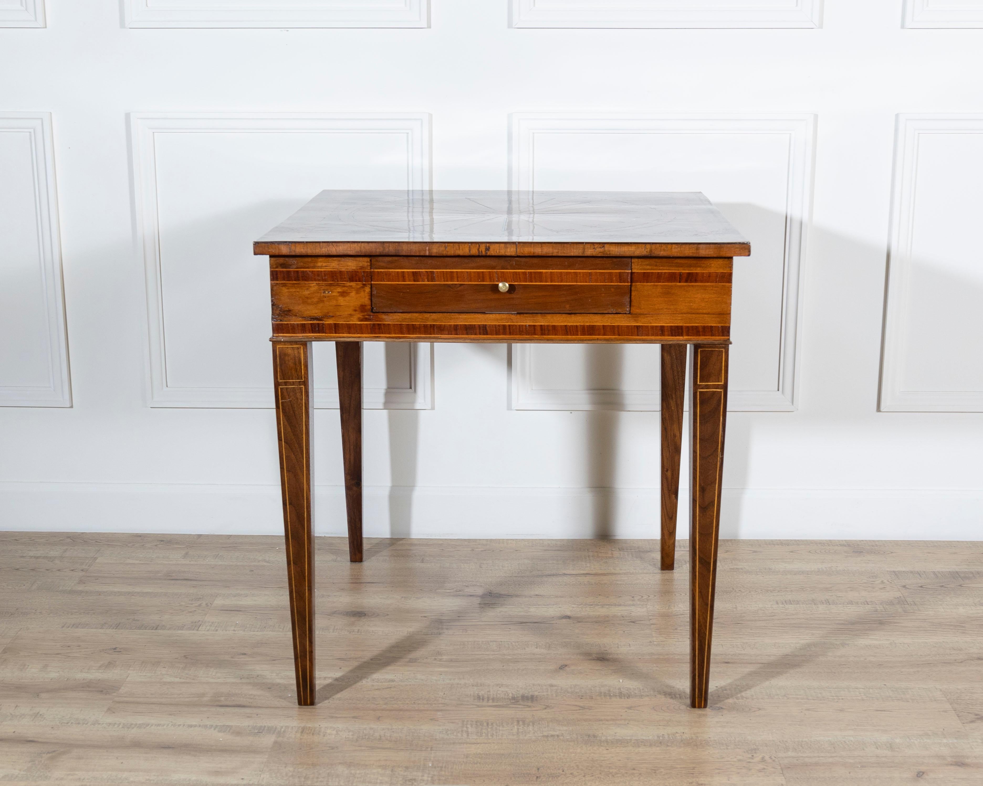 Una refinada mesa de estilo Luis XVI, fabricada en Italia a mediados del siglo XIX, en nogal con exquisitas incrustaciones de marquetería de maderas nobles. La parte superior rectangular está decorada con un elegante motivo geométrico e irradiado,