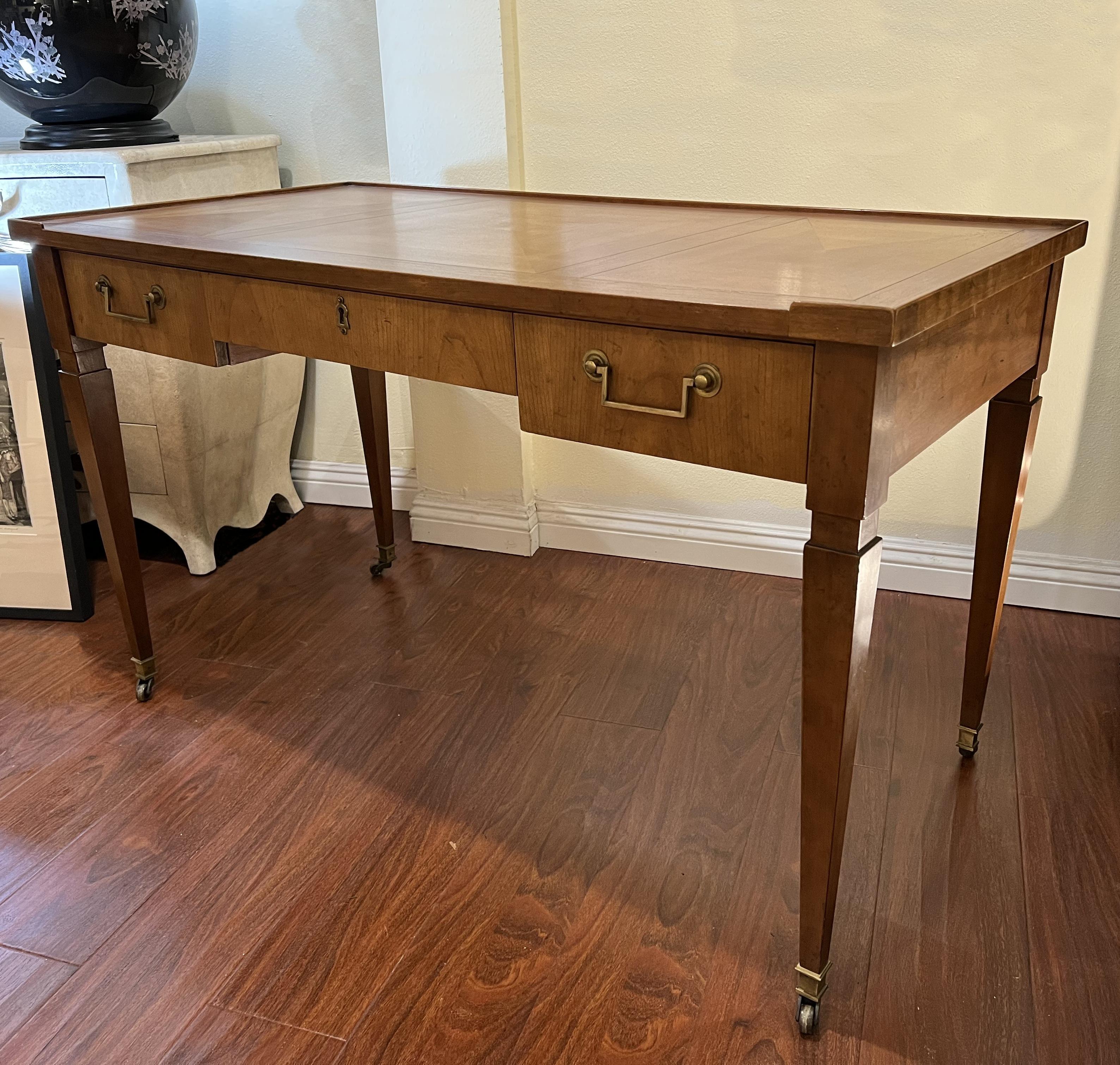 Walnut writing desk by Baker Furniture with brass handles.
A little flange around the back and sides is preventing your papers to fall down.