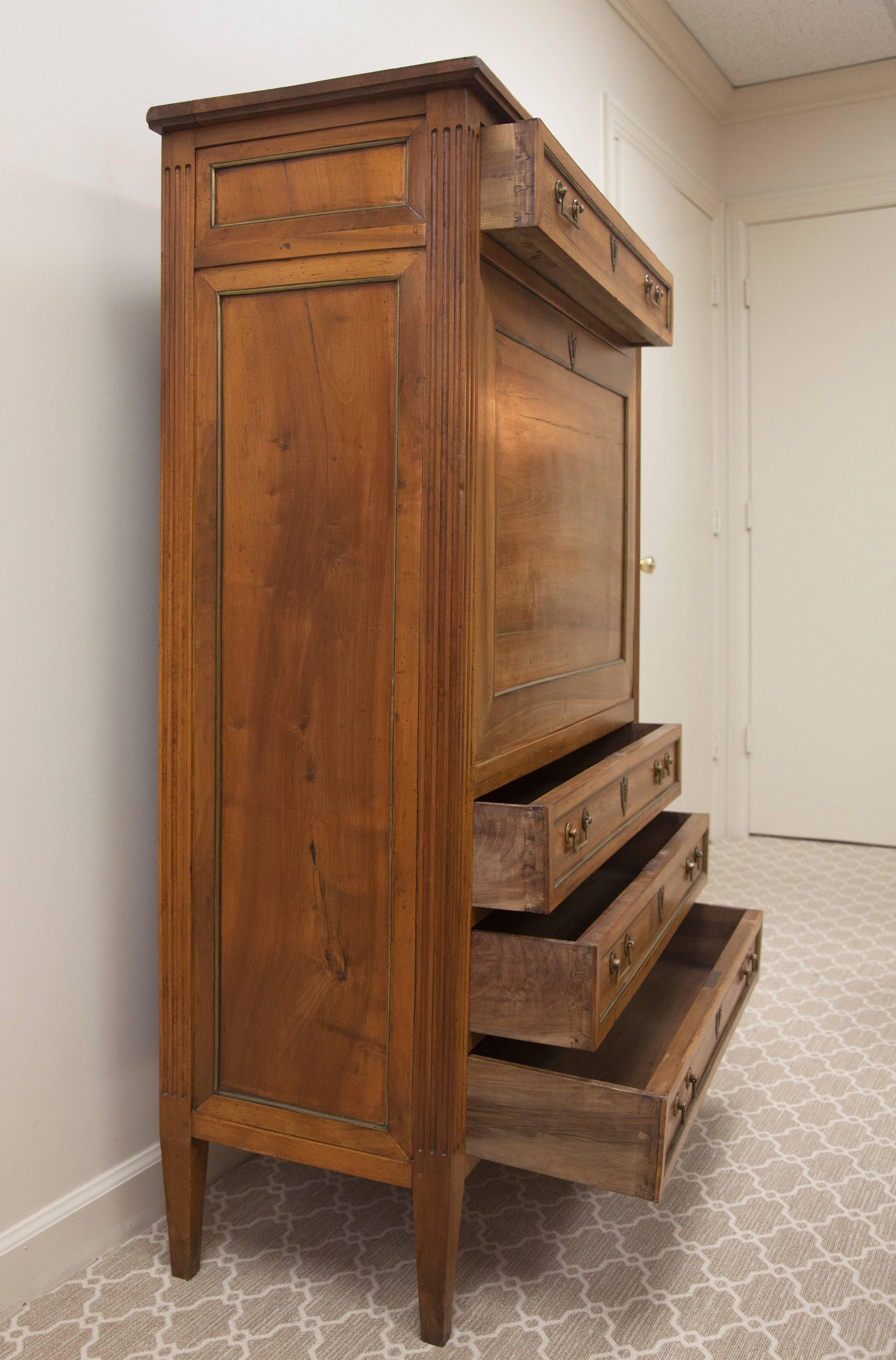 This Secretaire Abbatant features four drawers and a drop down front with black leather writing surface. The interior reveals six drawers and several open compartments. All of the drawer pulls and escutcheons are brass with the drawers and panels