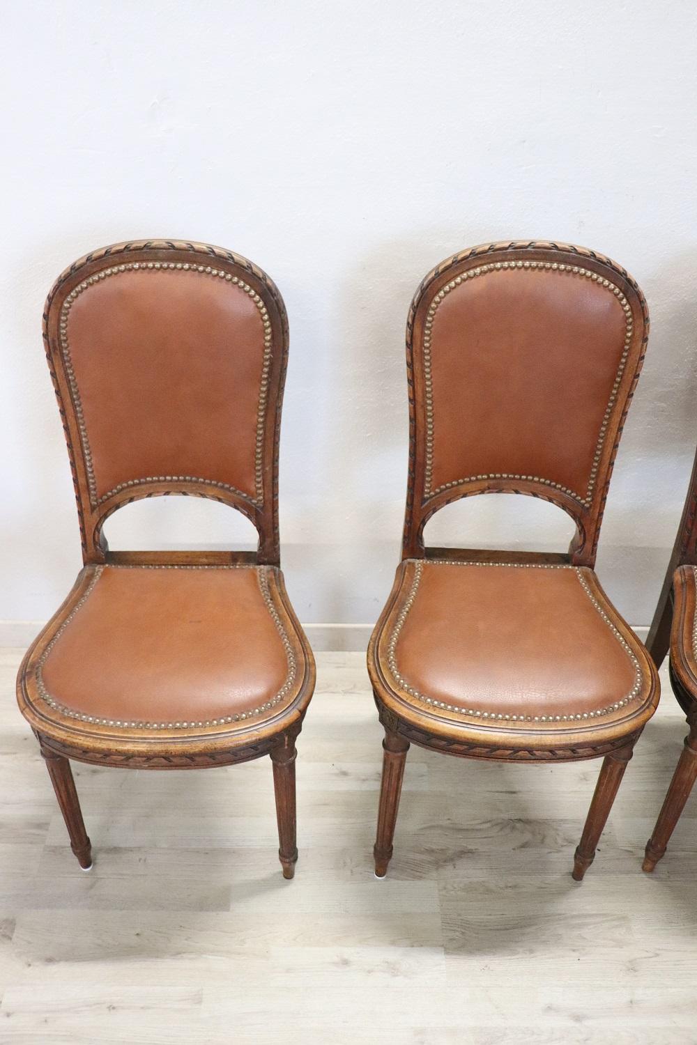 Series of four refined Italian early 20th century Louis XVI style walnut wood chairs. The chairs are characterized by refined seat in light brown imitation leather. Beautiful chairs ready to be placed in your beautiful home.