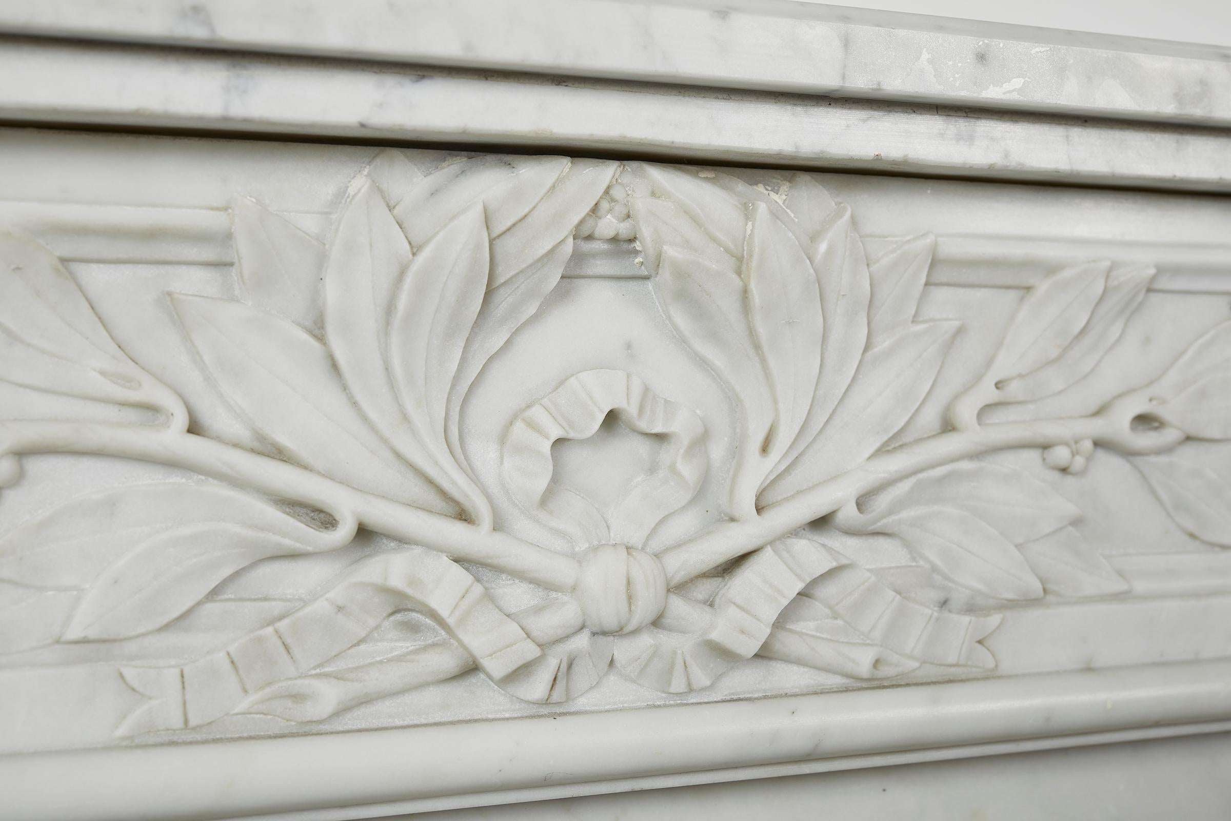 Louis XVI style white Carrara marble mantel (fireplace) with semi columns and olive palm motifs.
Interior dimensions: H 33, W 37.25 in.