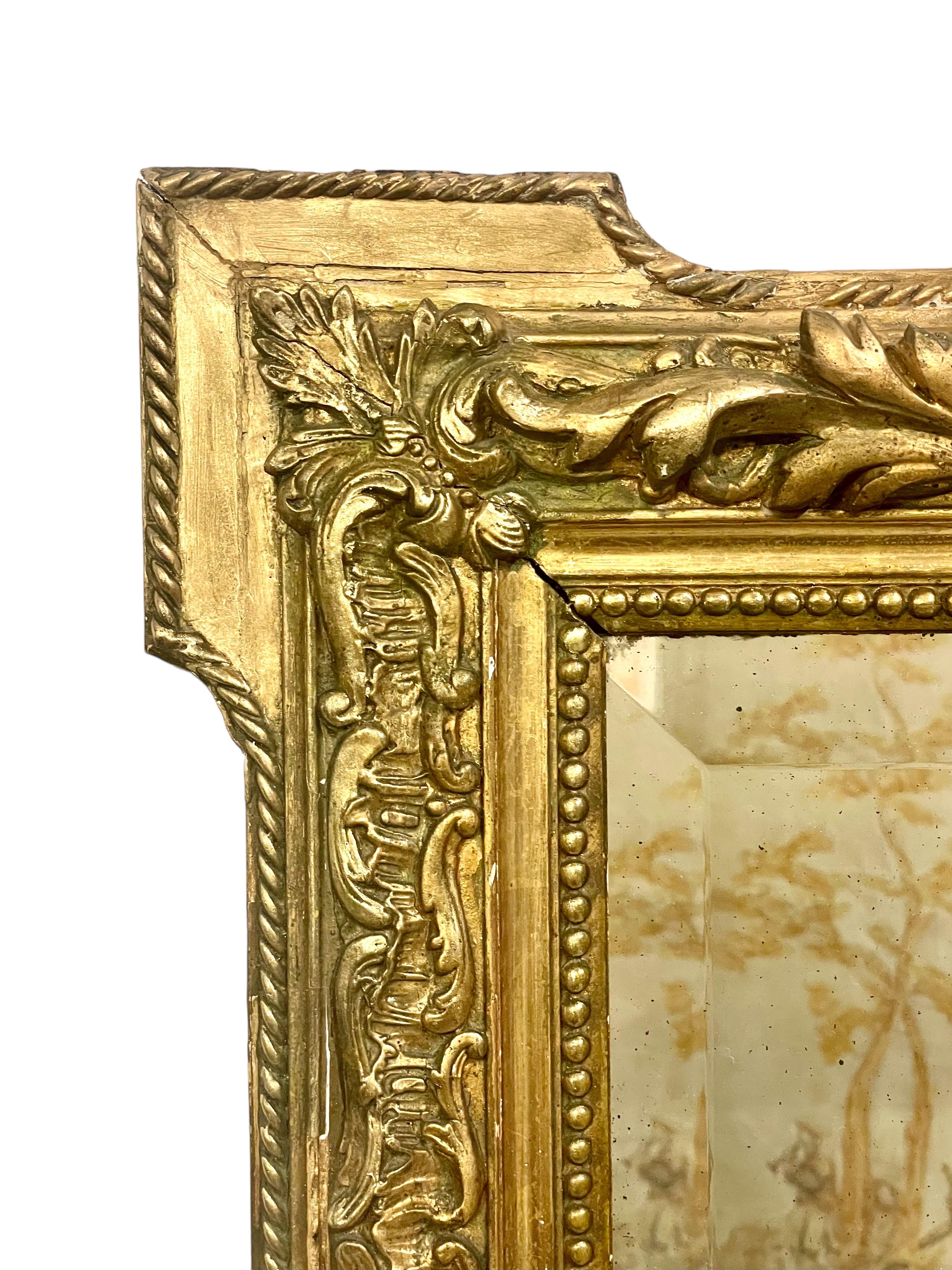 Un grand et impressionnant miroir de cheminée rectangulaire Napoléon III du XIXe siècle dans un cadre en bois et stuc doré, surmonté d'un imposant fronton de chérubins et de dauphins flanquant un médaillon ovale. Le cadre, avec ses moulures florales
