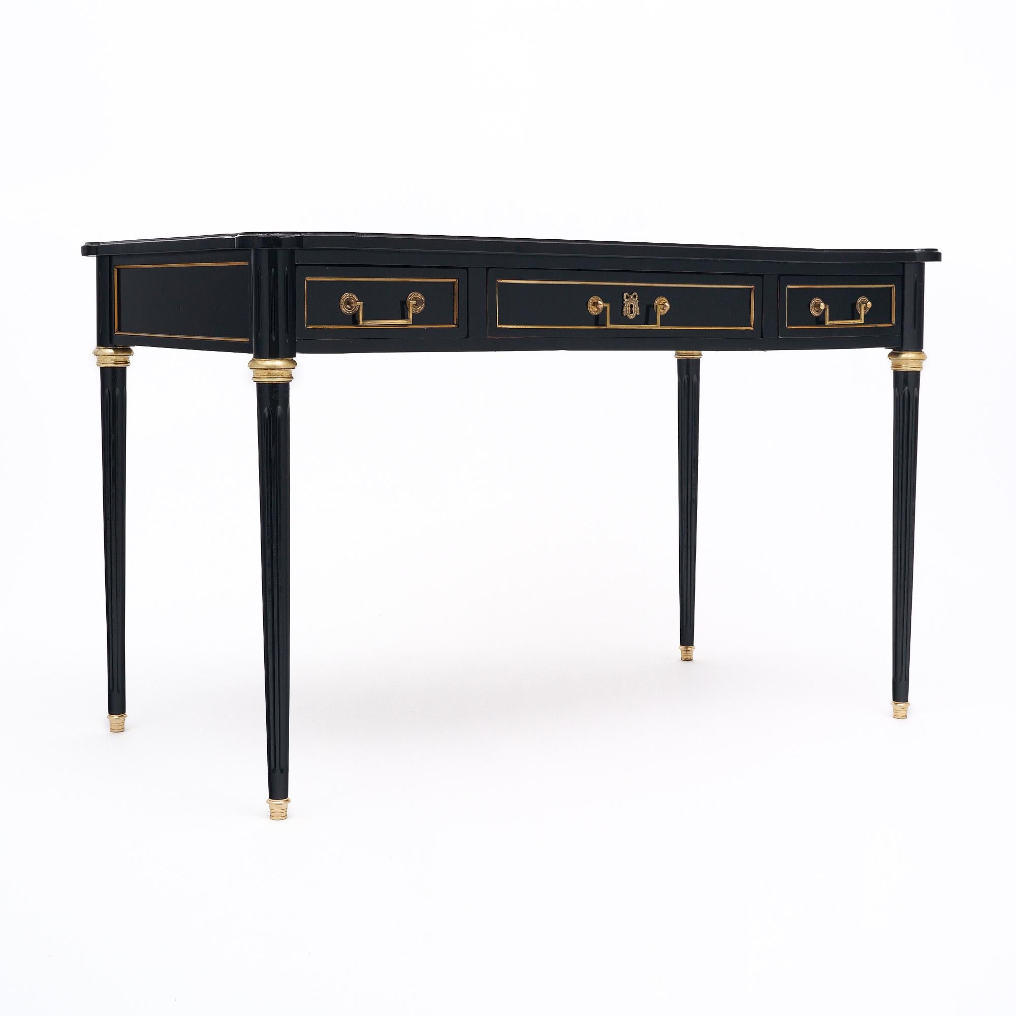 Writing desk from France in the Louis XVI style. This piece has been ebonized and finished with a lustrous French polish of museum-quality. There are three dovetailed drawers all with original brass hardware. The top of the desk is covered in a