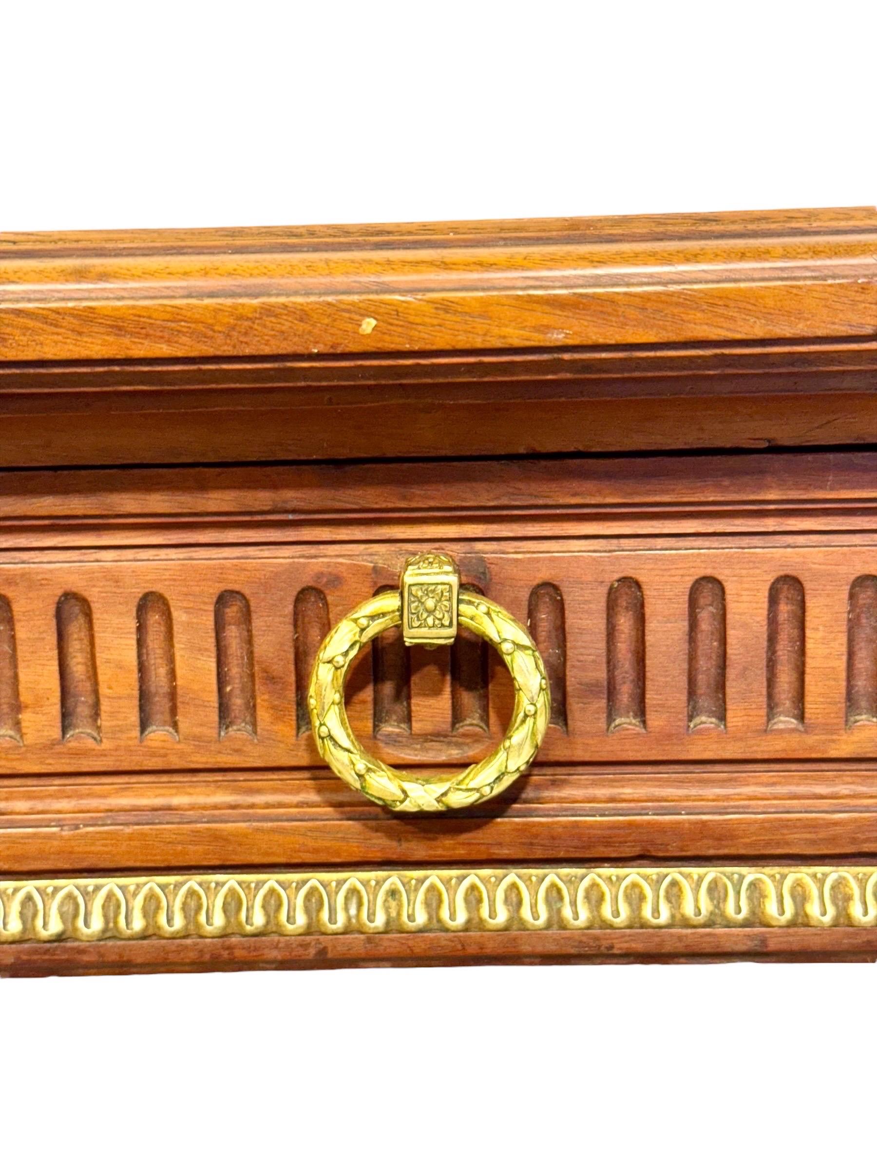 This elegant Louis XVI style writing table, dating from the late 19th century, embodies the refined neoclassical taste that defined French furniture of the period. Crafted from walnut veneer with a warm patina, the rectangular top is framed with