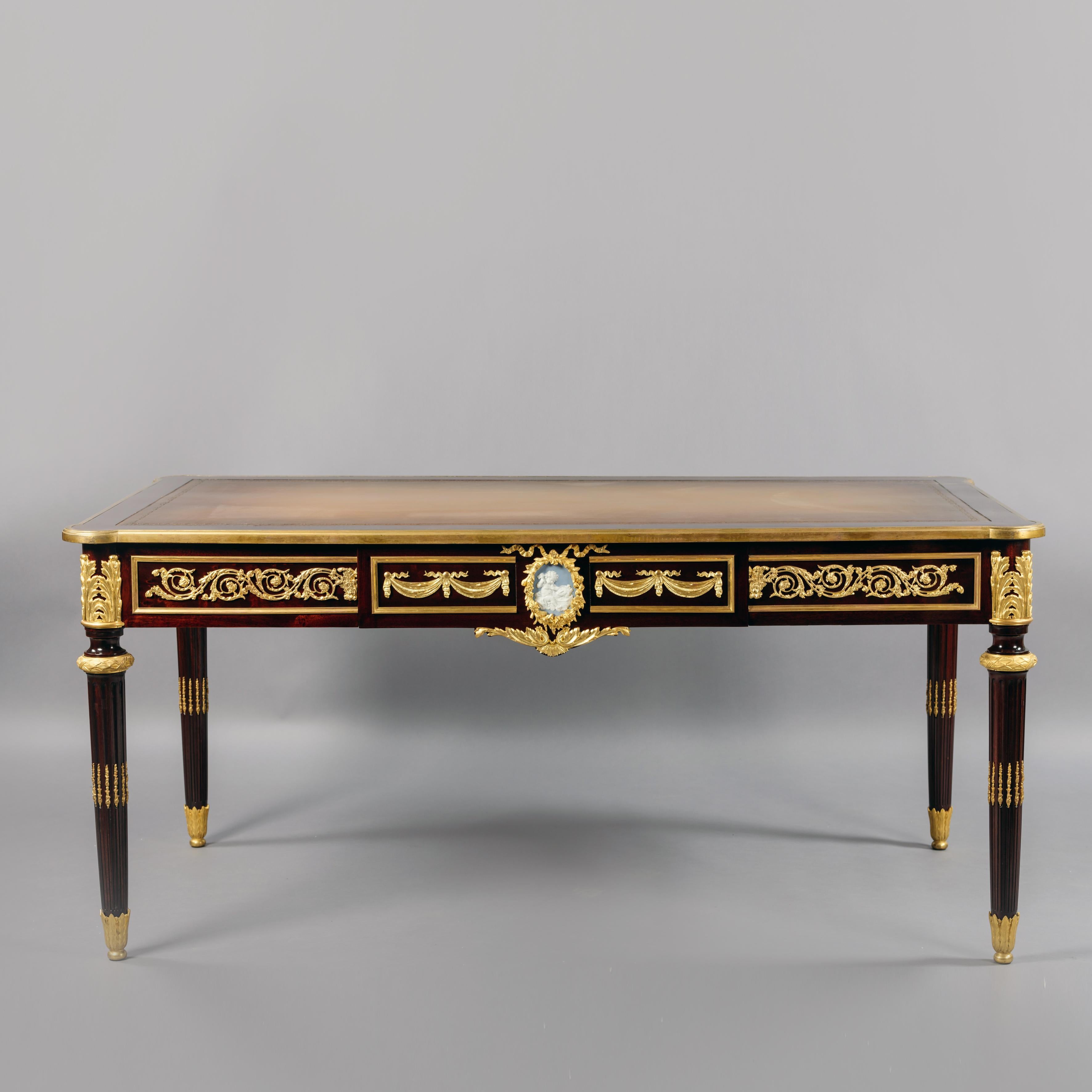 A Louis XVI style gilt bronze and Jasperware mounted mahogany Bureau plat.

Stamped 'FOURNIER' to the reverse of the bronze mount to the drawer apron. .

This fine bureau plat or writing table is fitted with a single drawer. The frieze to each