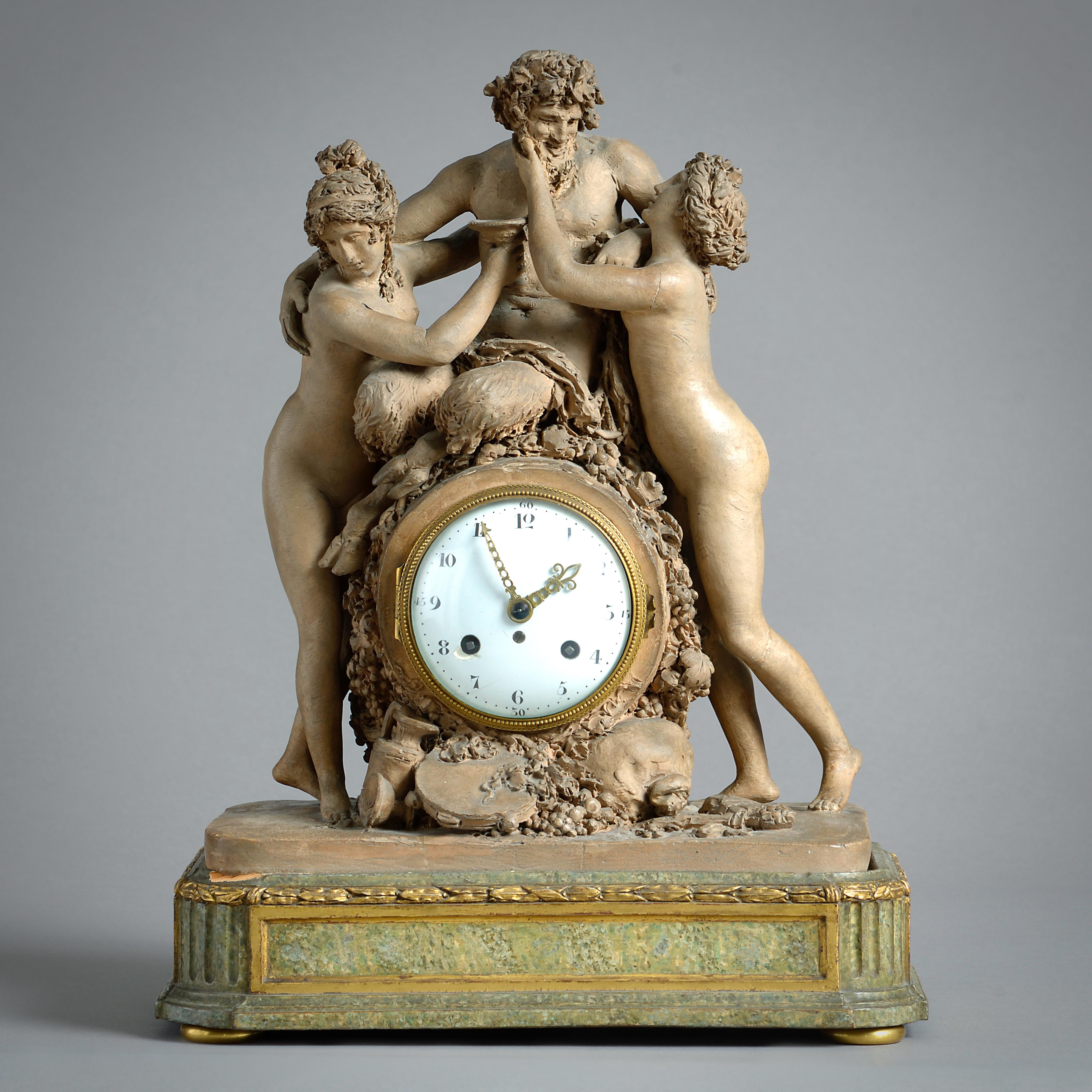 A FINE LOUIS XVI TERRACOTTA AND SIMULATED-MARBLE STRIKING MANTEL CLOCK, THE TERRACOTTA BY JOSEPH-CHARLES MARIN, CIRCA 1785.

The drum case modelled as a wine cask supporting a seated figure of the drunken Silenus flanked by twin naked Bacchantes,