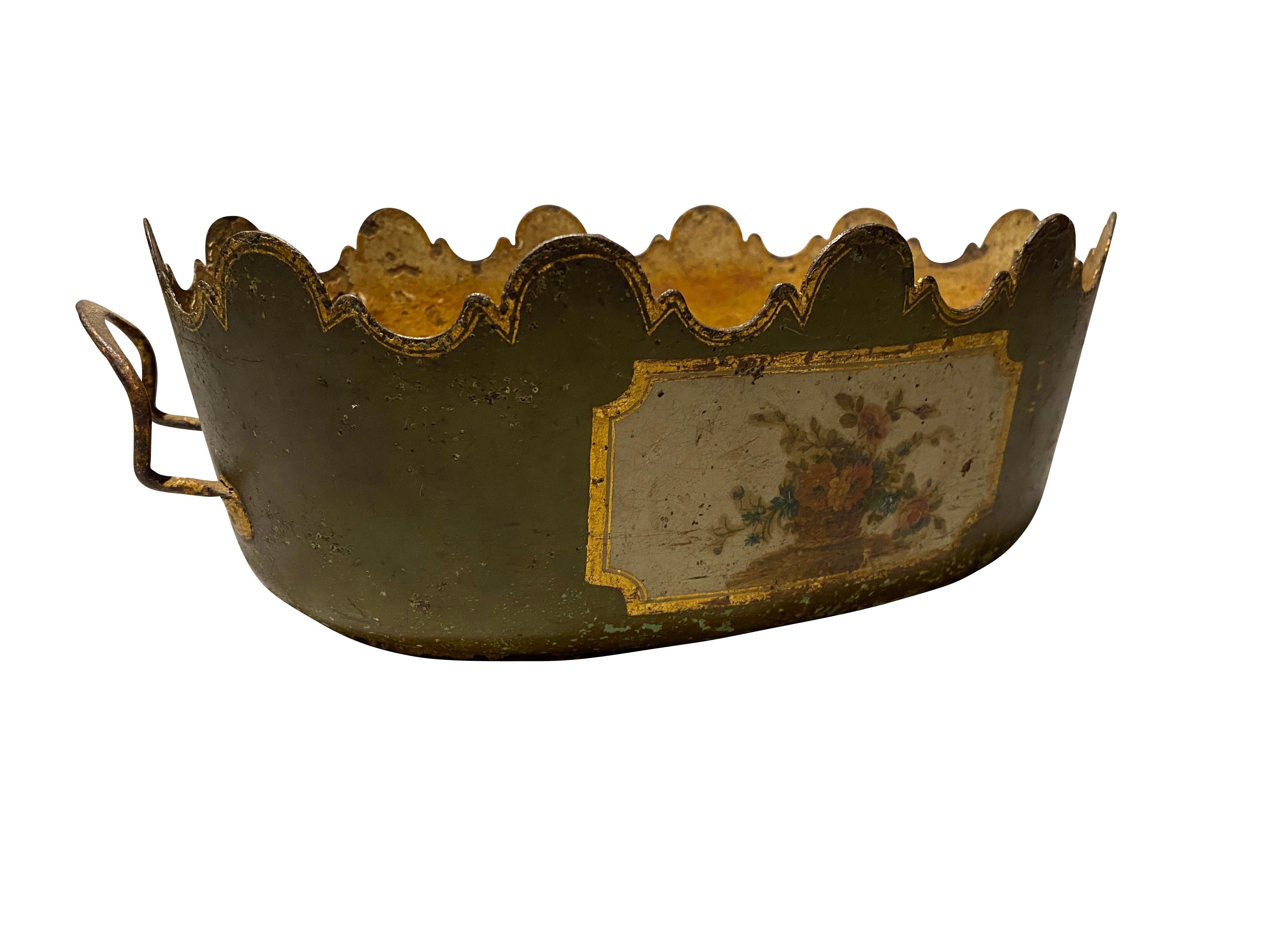 Oval with handles and a pale green with central panel of a floral still life. Serrated edge with overall gilded details.