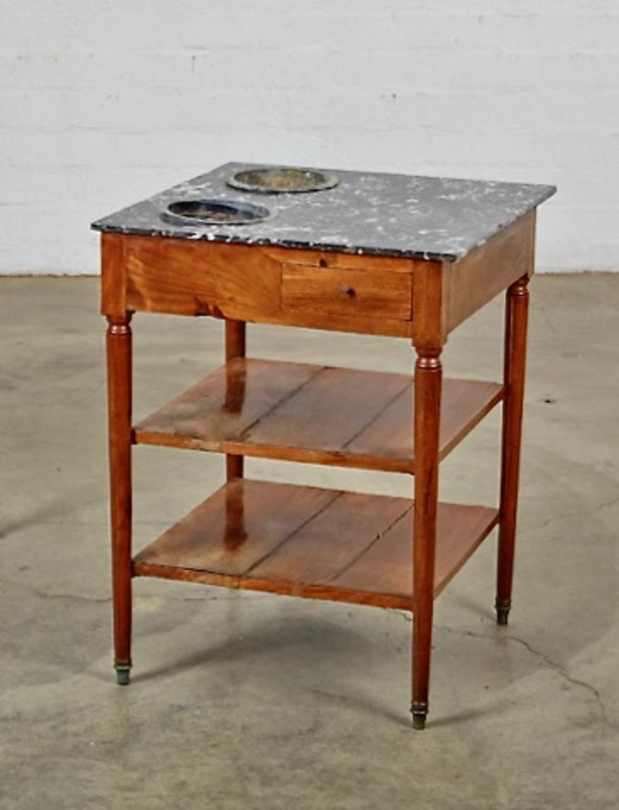 This is a charming late 18th century/early 19th century Rafraichissoir or wine/champagne coolert that has retained its original surface and basins. The table is in good overall condition with the exception of the shelfs directly below the basins