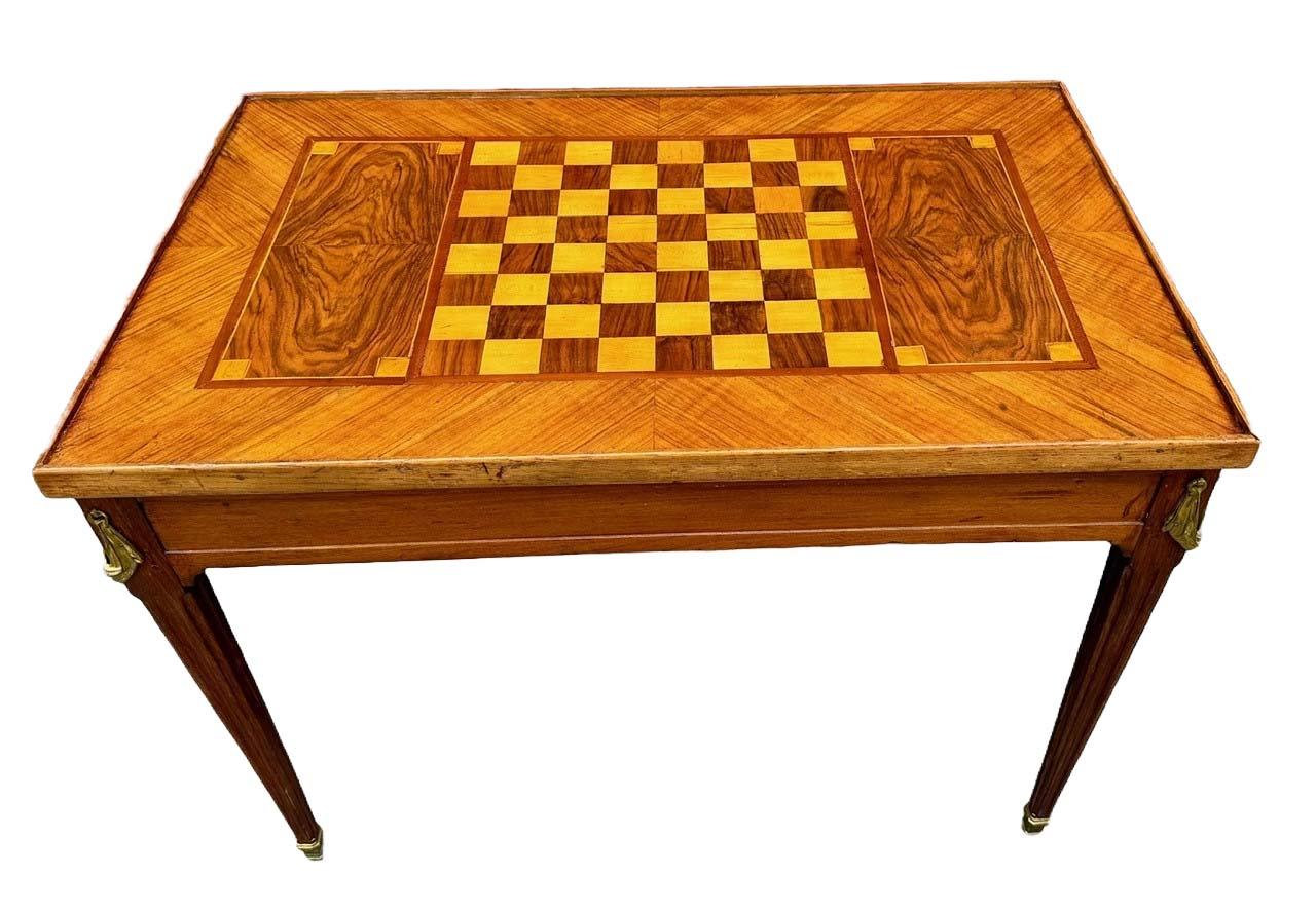 Mesa de juegos francesa Luis XVI Tric Trac de nogal macizo, chapado de nogal exótico, monturas de bronce, patas cónicas cuadradas con columnas estriadas y sabots de bronce. Fabricada en rico nogal y adornada con chapa de nogal, encarna la elegancia