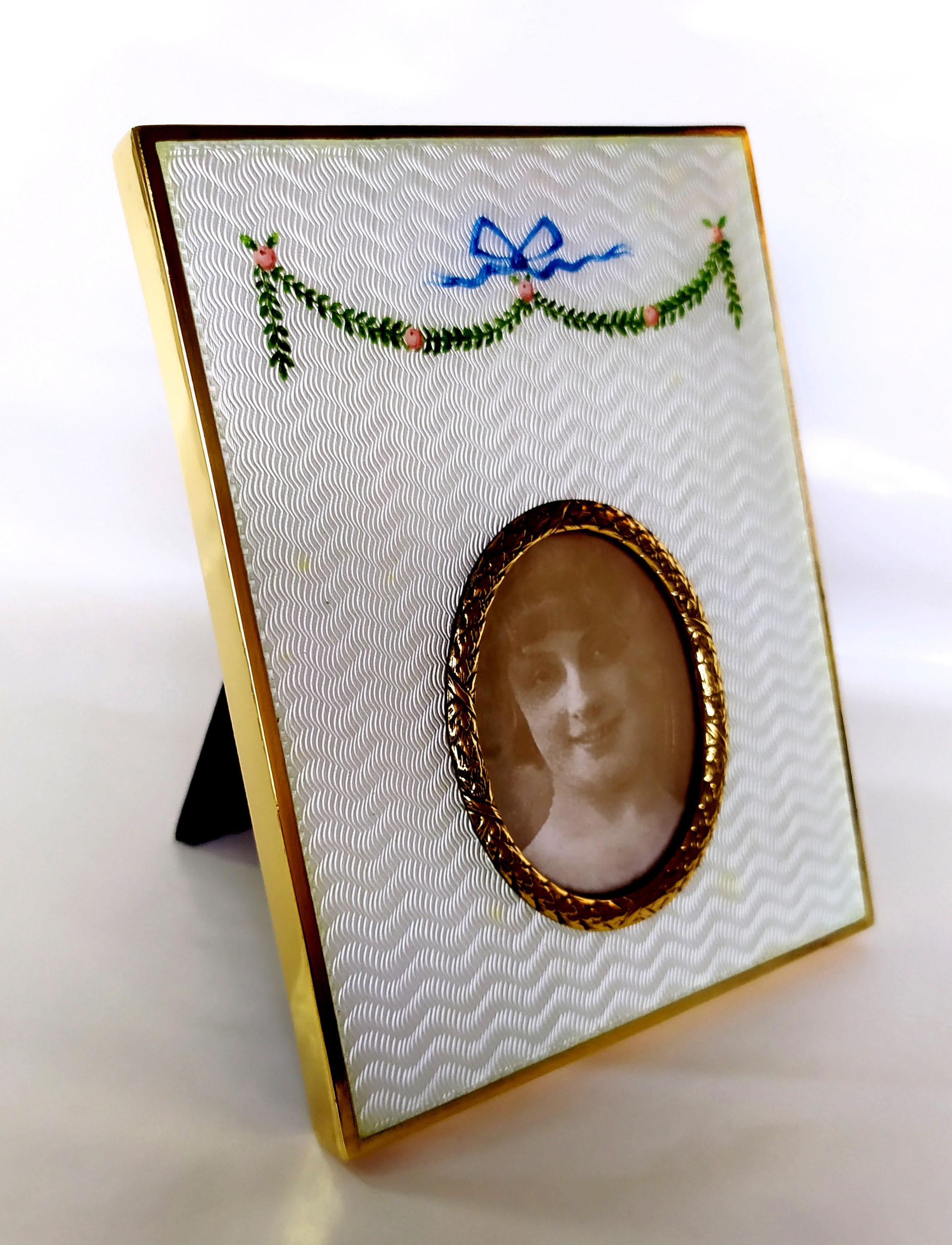 Rectangular photo frame in 925/1000 sterling silver gold plated with translucent fired enamel on guillochè and hand-painted miniature of a garland of flowers with oval border internal size cm. 4 x 5.2 Russian Empire Faberge style. External cm. 10 x