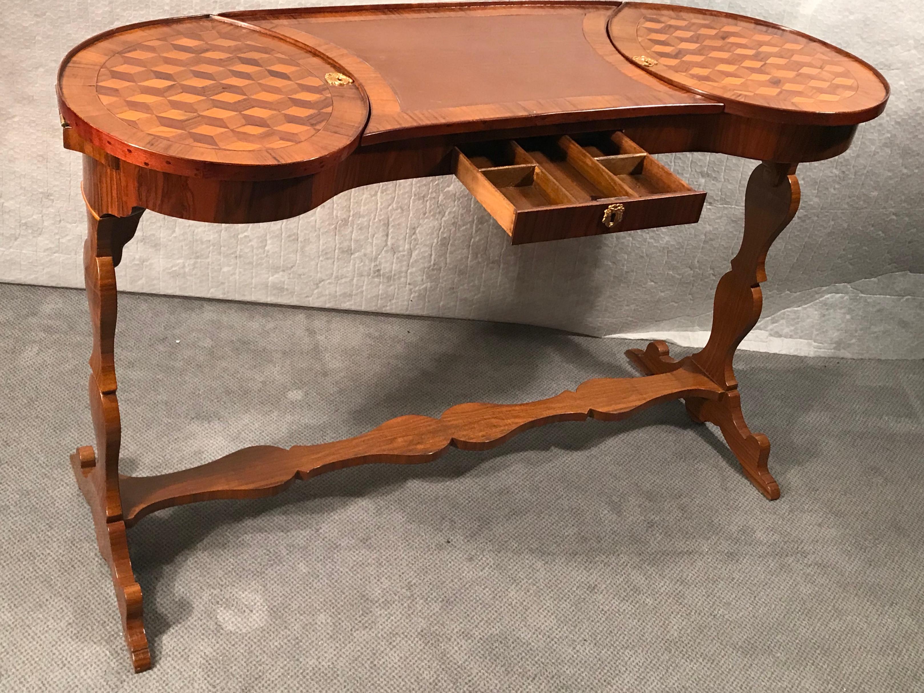 Exquisite and very unusual kidney shaped working table, France 1780, walnut, maple, plum wood veneer and marquetry. With a leather top and a flap on each side. One central drawer. Beautiful piece in very good original condition.