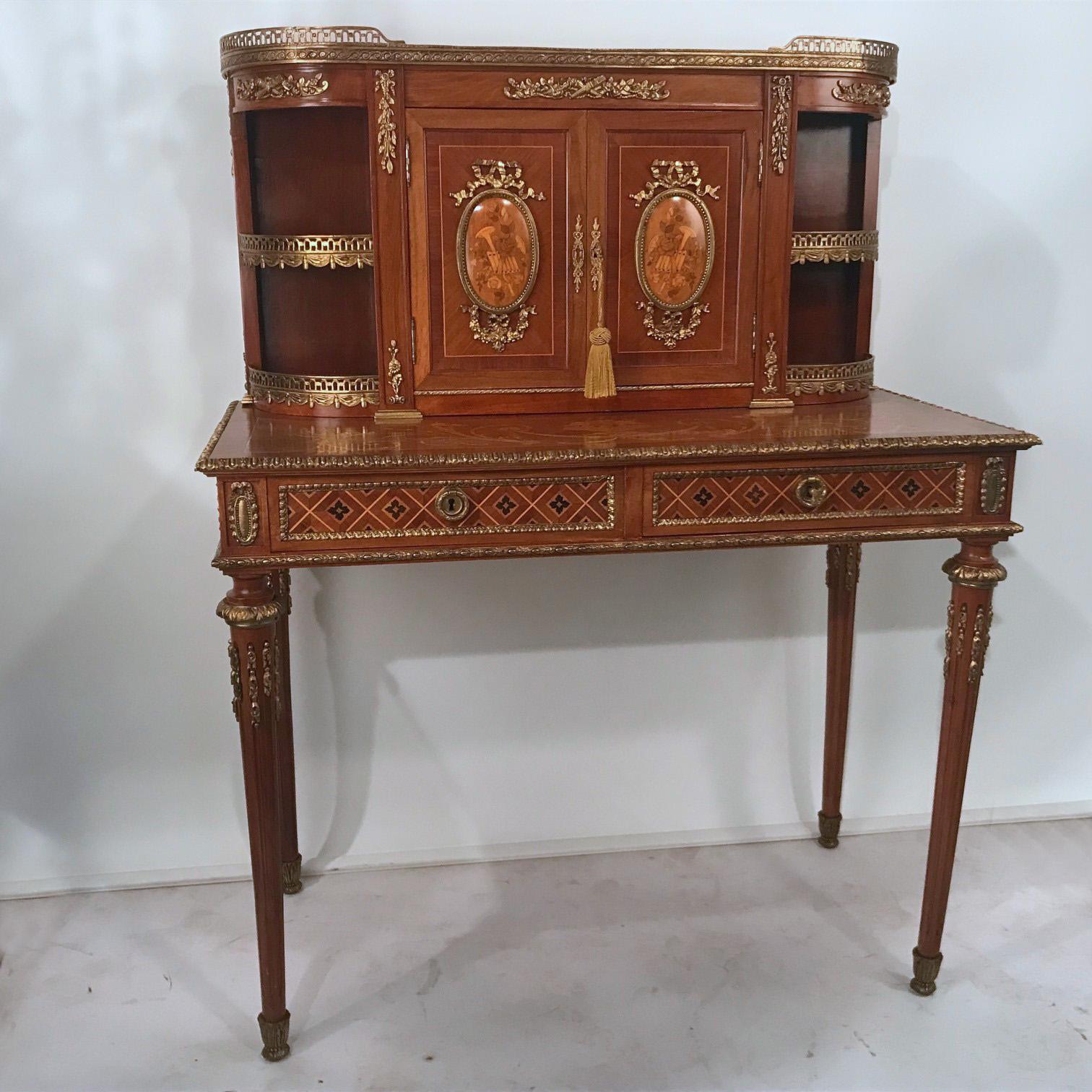 A writing table with a fitted superstructure, this beautifully crafted and elegant piece has all the positive attributes. The upper section is enclosed by a pair of doors each with oval panels inlaid with musical trophies; the lower with two frieze