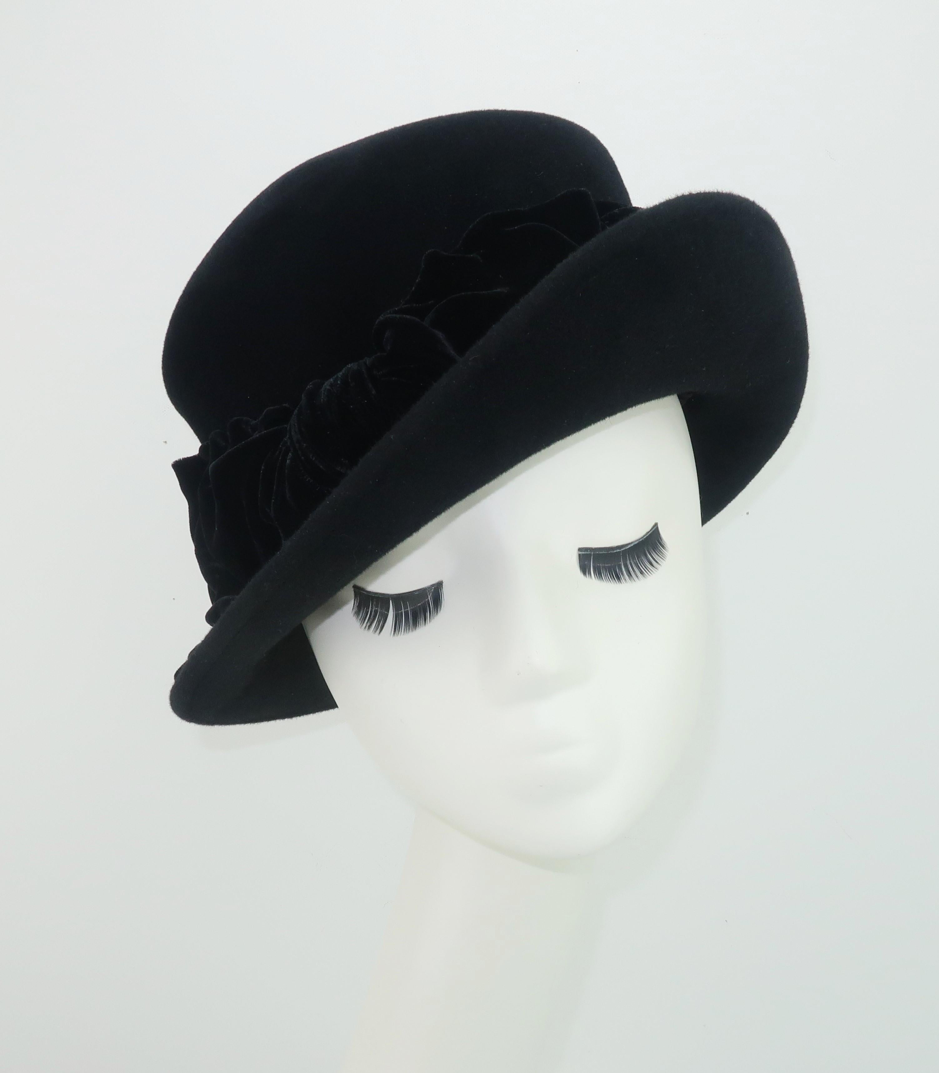 A vintage inspired black wool felt hat with upturned brim and crushed velvet bow by British born and Los Angeles based milliner, Louise Green.  From the beginnings of her millinery business in 1987 until her recent retirement, Ms. Green has been