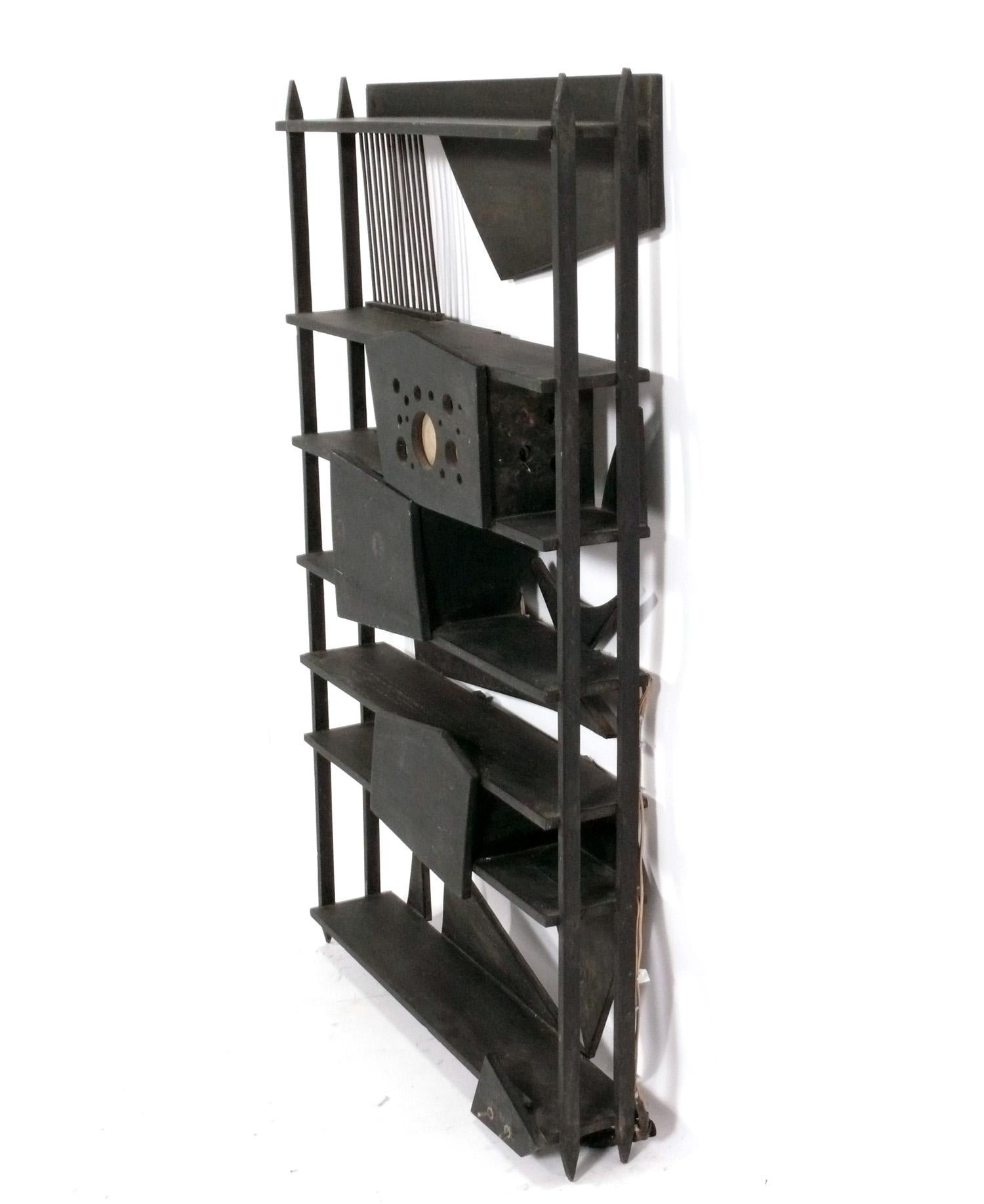 Sculptural Bookshelf, in the manner of Louise Nevelson, unsigned, American, circa 1960s. This wall mounted shelf has space to store books or display items, and has a lighted area that emits a soft glow. 