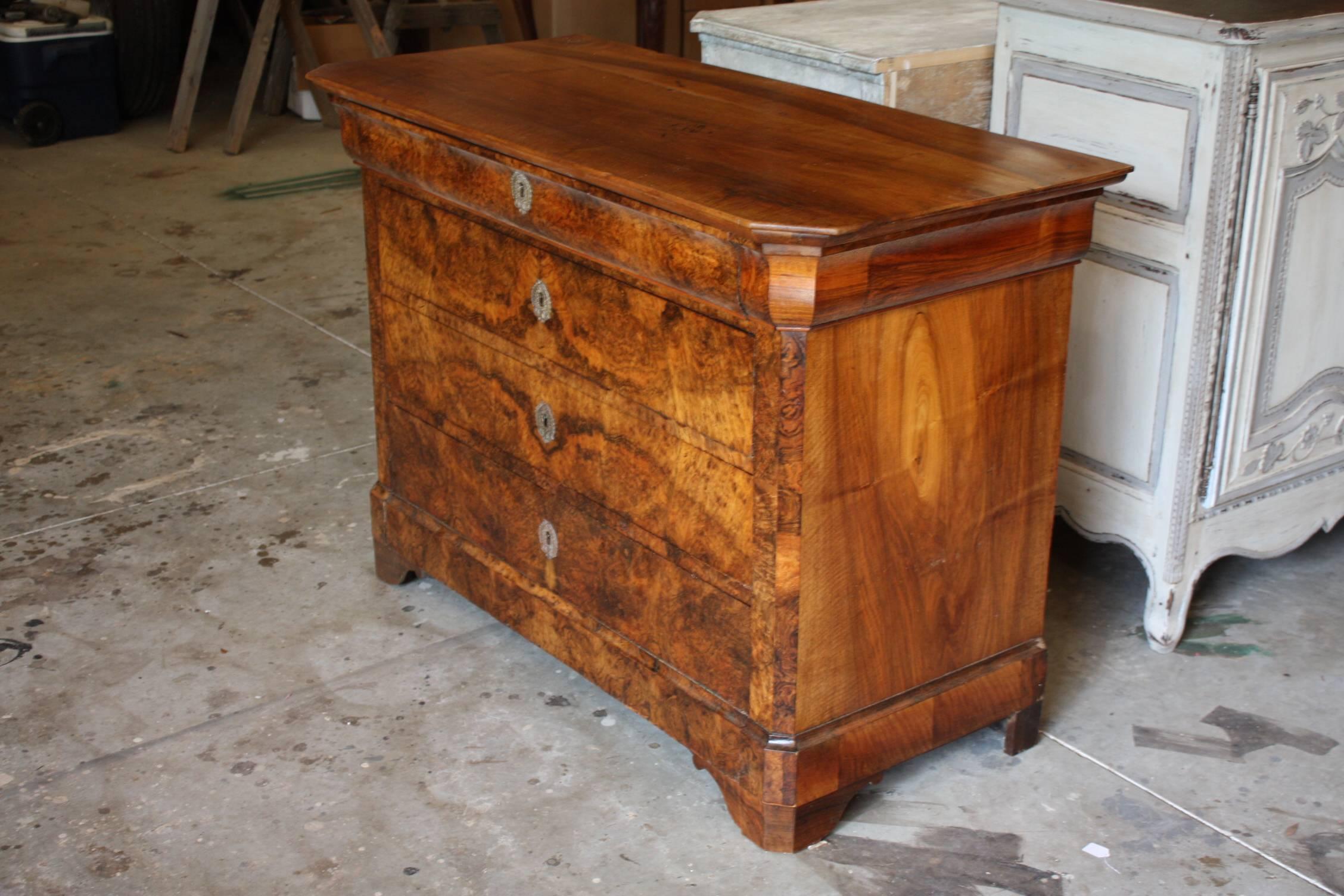 This is a spectacular Louis Phillip walnut commode with a rectangular top above and in-curving narrow frieze drawer over three long drawers raised on bracket feet. Beautiful rich patina!