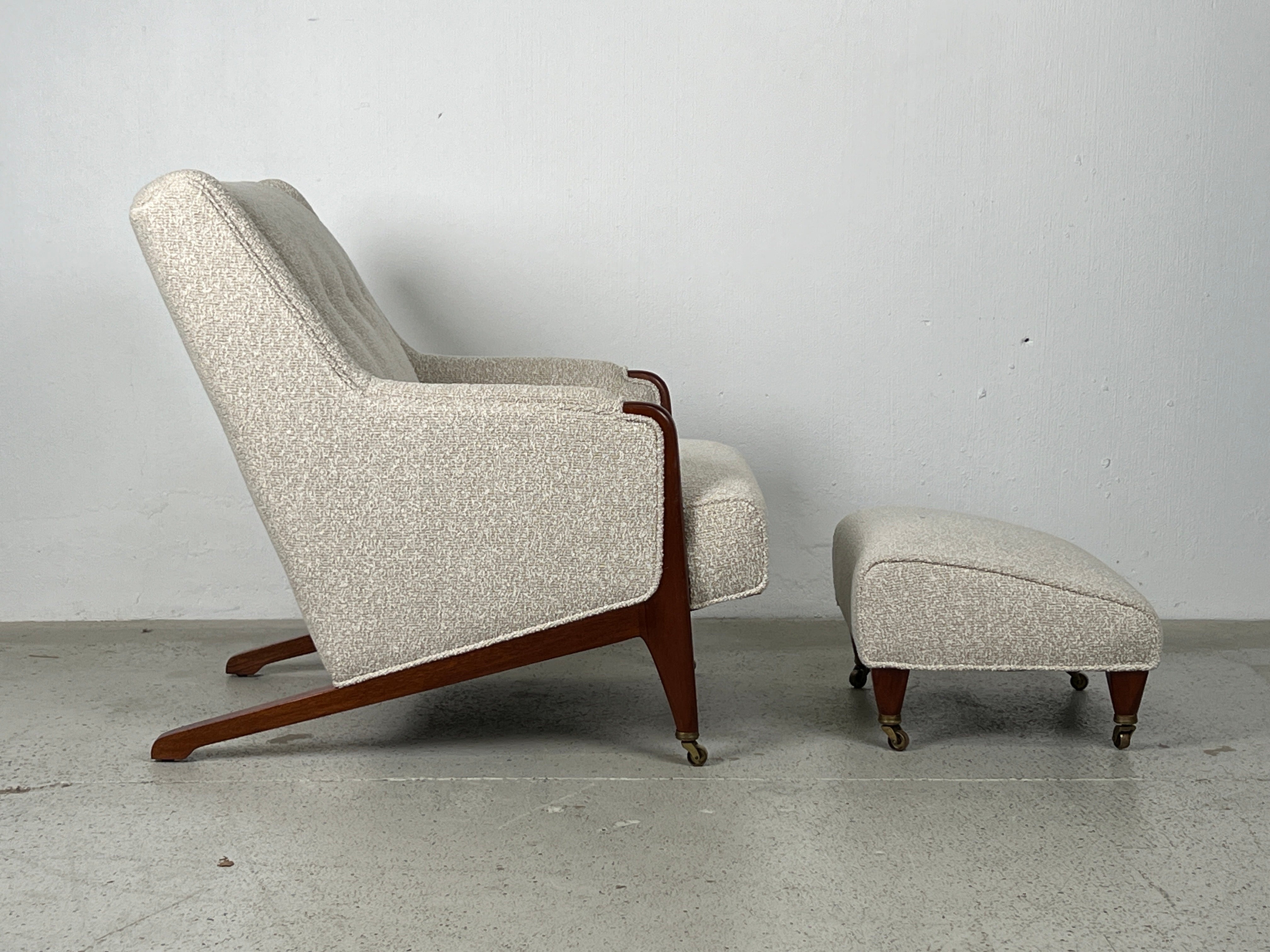 A rare lounge chair and ottoman with mahogany legs and brass casters. Designed by Edward Wormley for Dunbar. Reupholstered in Holly Hunt fabric. 
